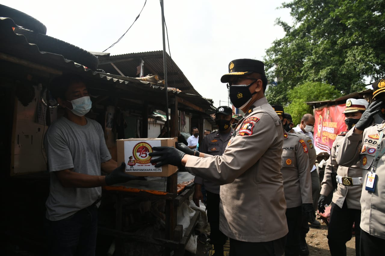 Karojianstra Slog Polri Brigjend Budi Siswanto menyerahkan bantuan ke salah satu pemulung di Pulo Gadung, Jaktim, Rabu (30/6)