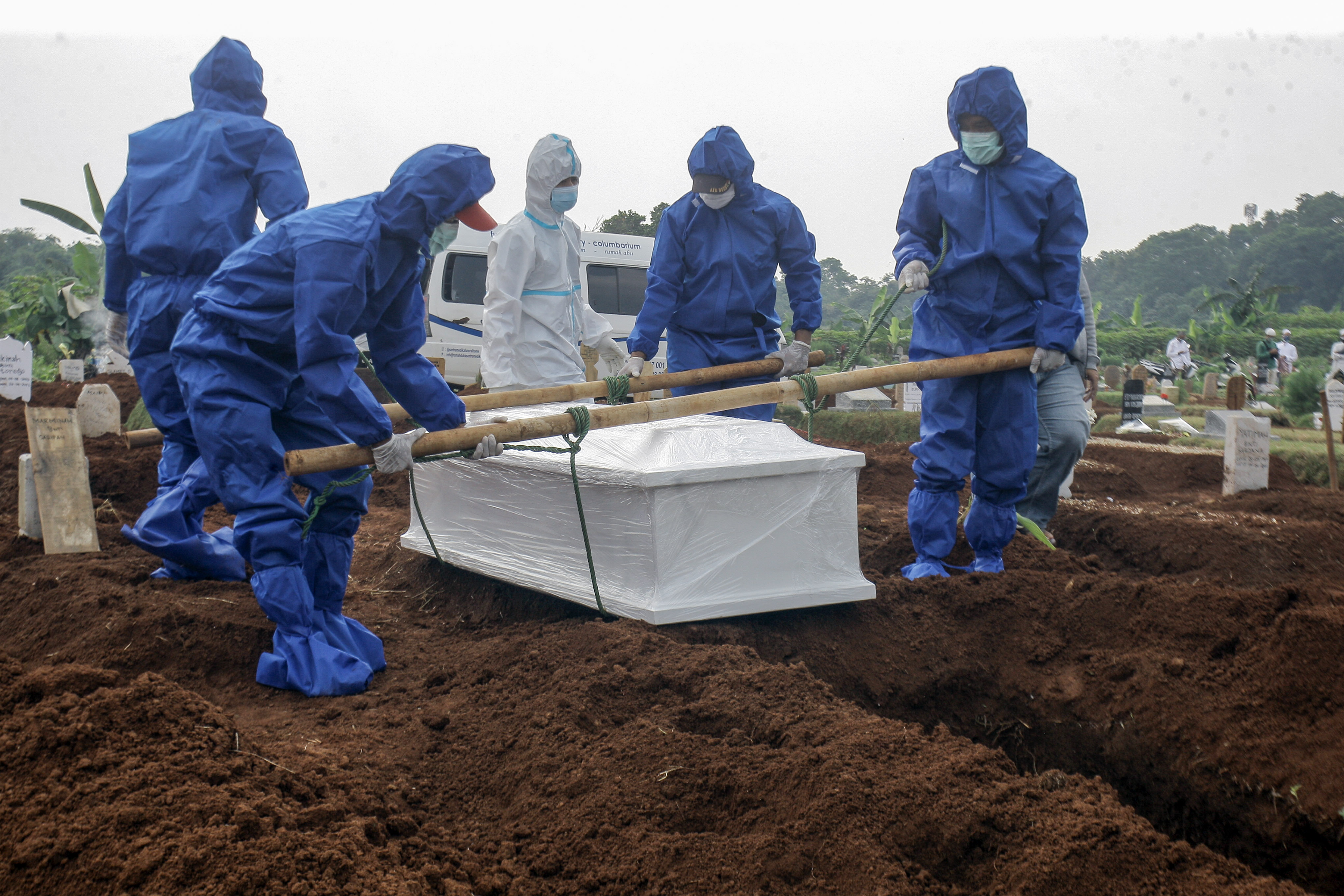 Petugas pemakaman membawa peti jenazah korban COVID-19