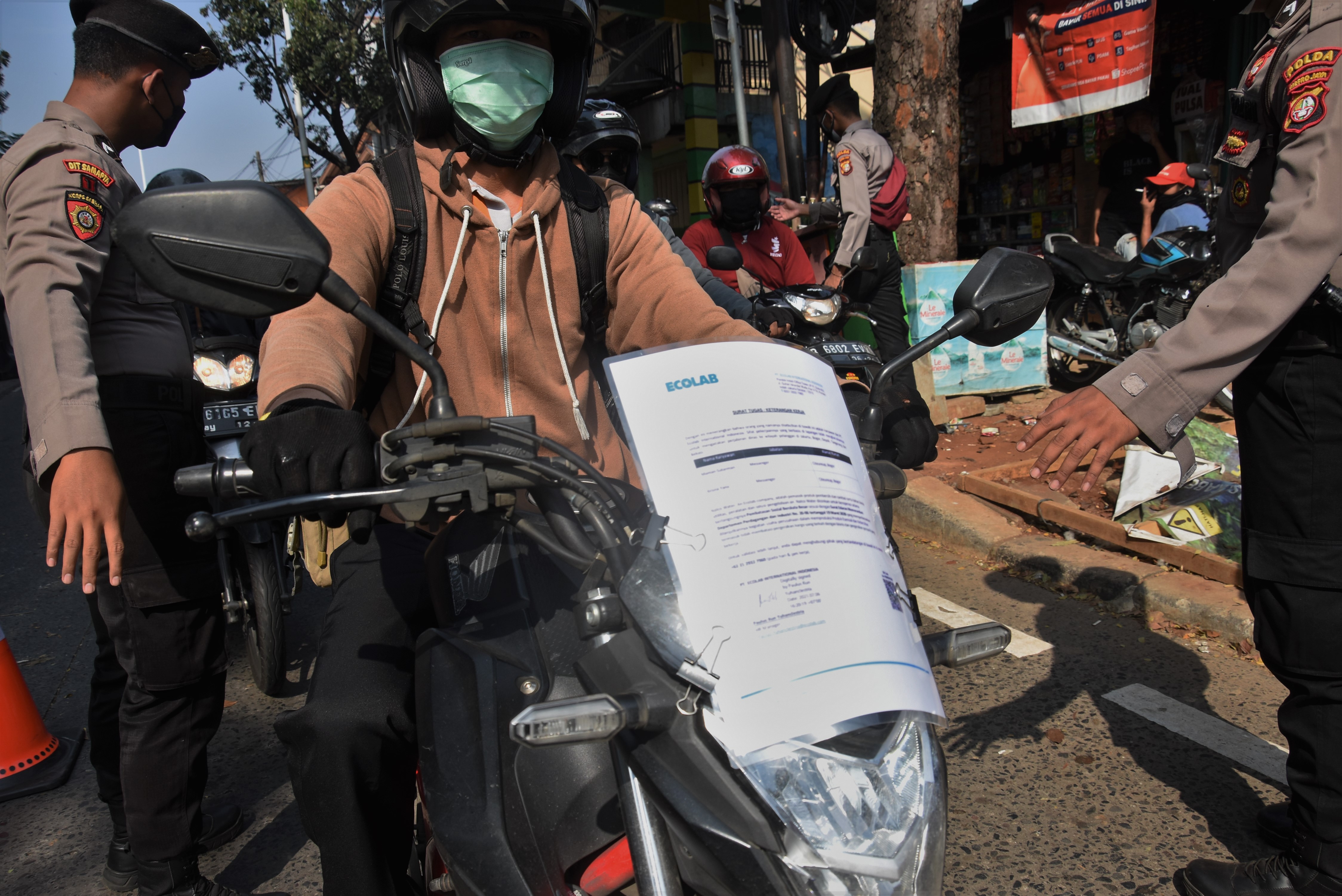 Pengendara menempel Surat Tanda Registrasi Pekerja (STRP) di bagian depan motornya saat melintasi pos penyekatan di Jl.Lenteng Agung, Jaksel