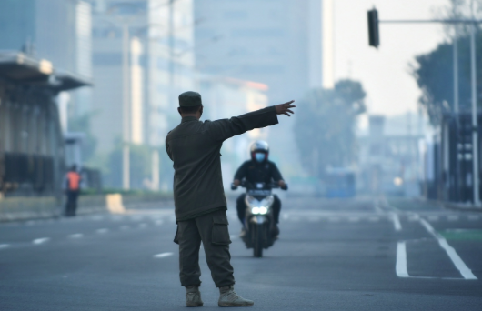  Petugas Satpol PP mengarahkan kendaraan agar keluar dari jalan Sudirman-Thamrin yang sedang ditutup di Kawasan Bundaran HI, Jakarta.