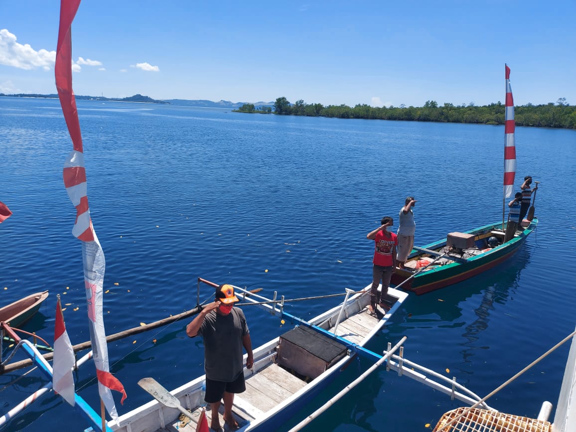 Sejumlah nelayan mengikuti upacara 17 Agustus dari kapal mereka di Dermaga Pangkalan Armada Keamanan Laut Bakamla Serei, Likupang Barat.