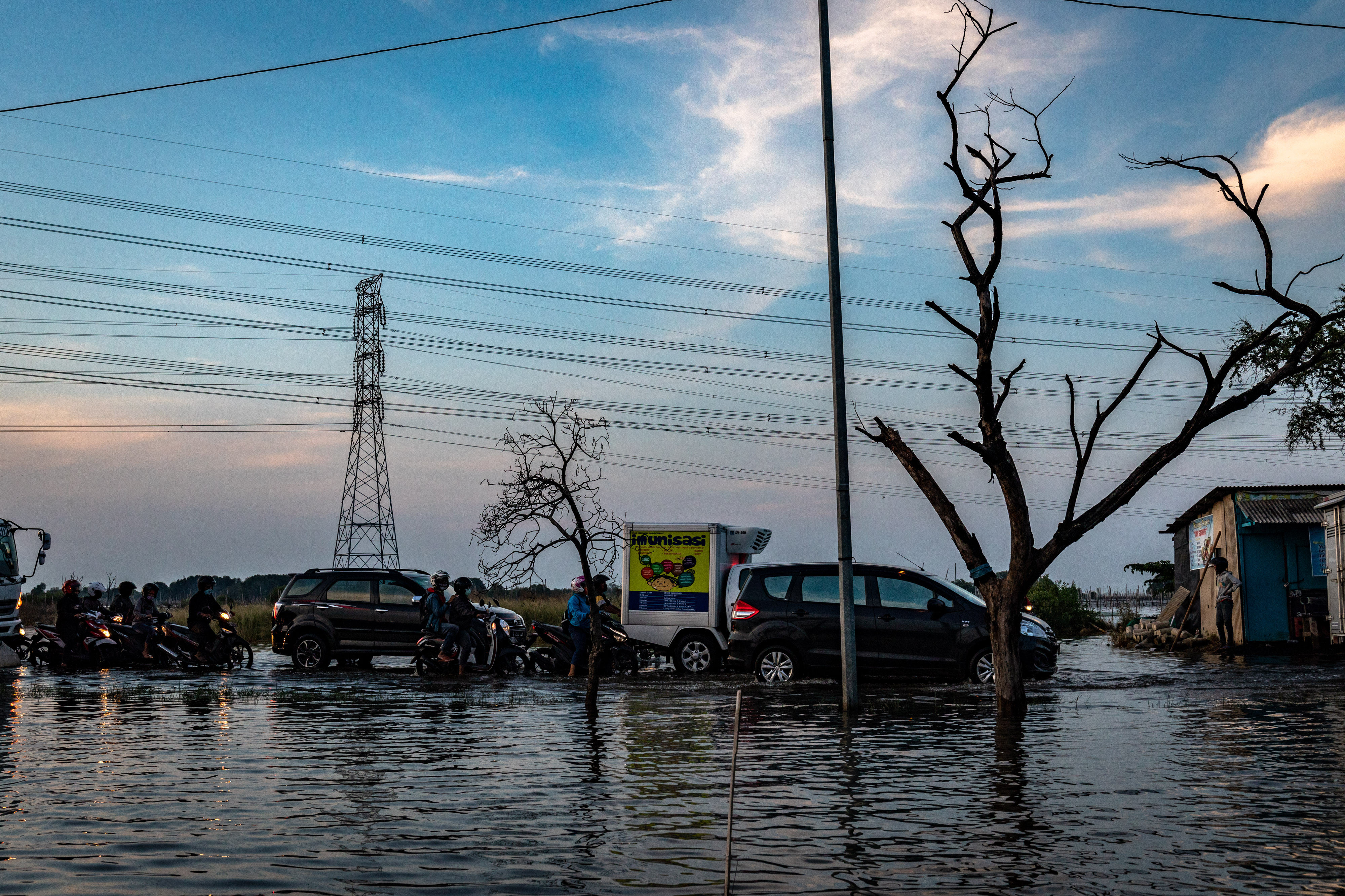Sejumlah kendaraan bermotor menembus jalur pantura yang terendam banjir rob.