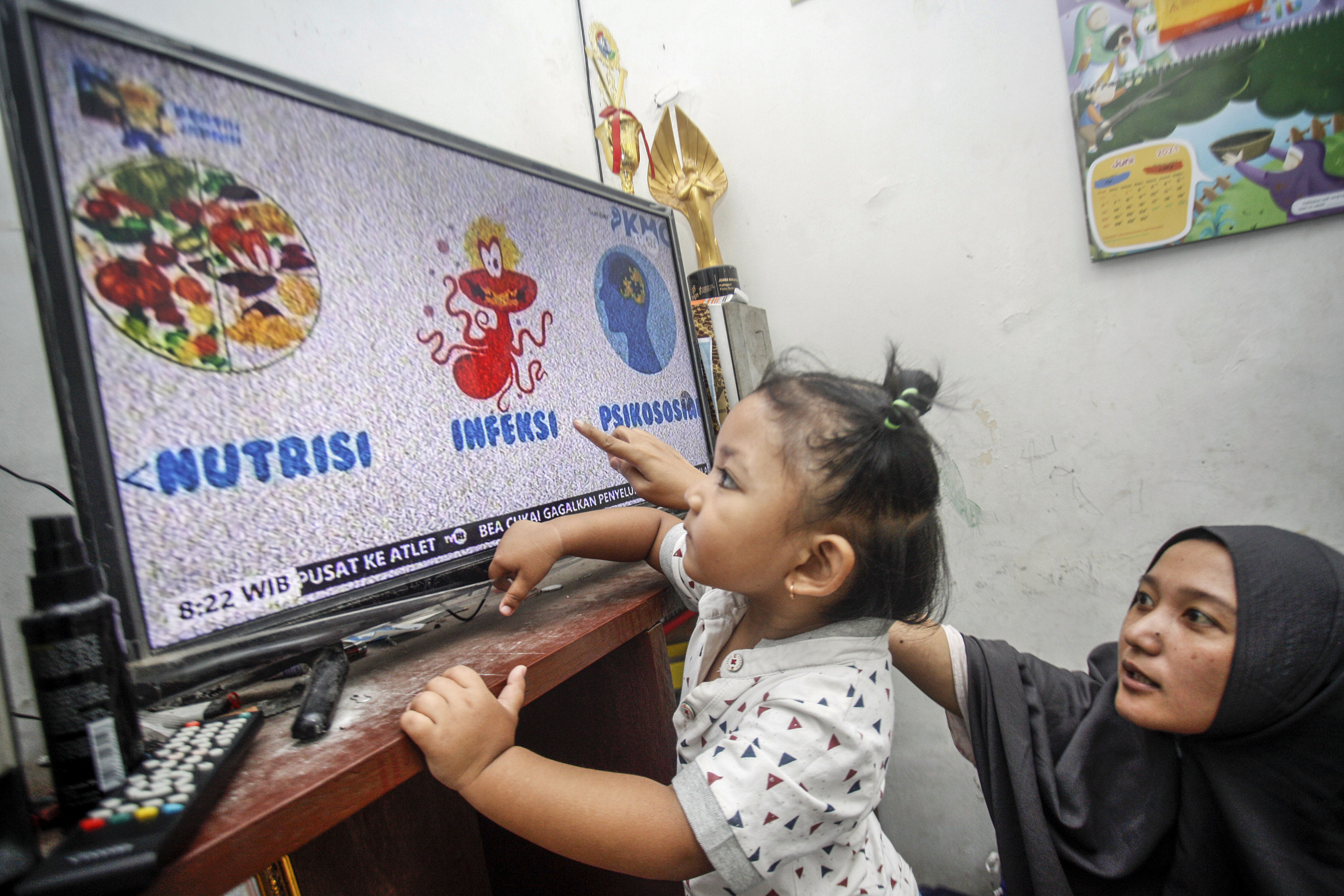 Warga menonton televisi di rumahnya, Depok, Jawa Barat.