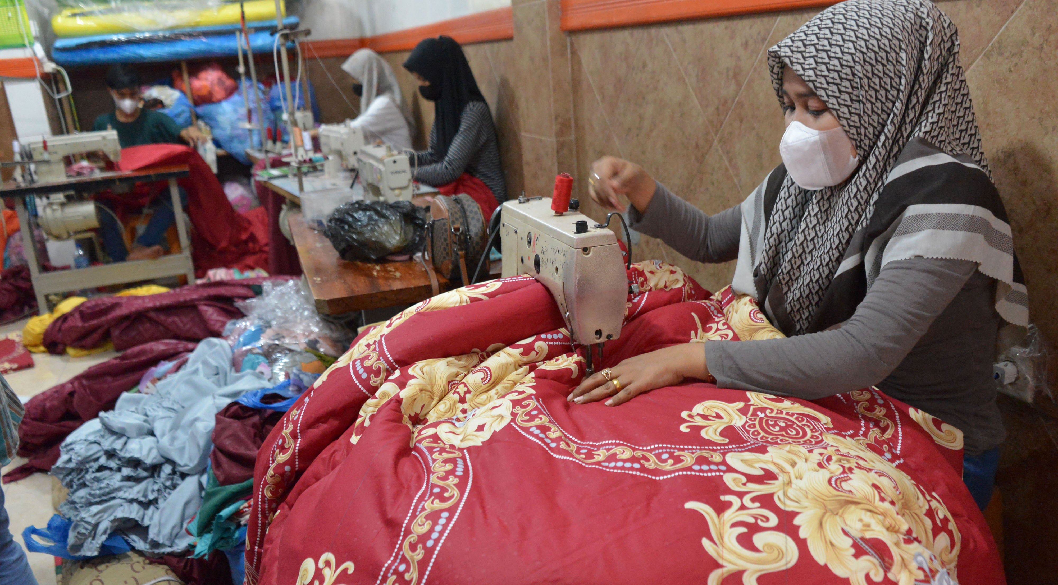 Pekerja menyelesaikan pembuatan berbagai jenis produk sprei dan sarung bantal di salah satu usaha konveksi, Banda Aceh, Aceh, Sabtu (28/8).