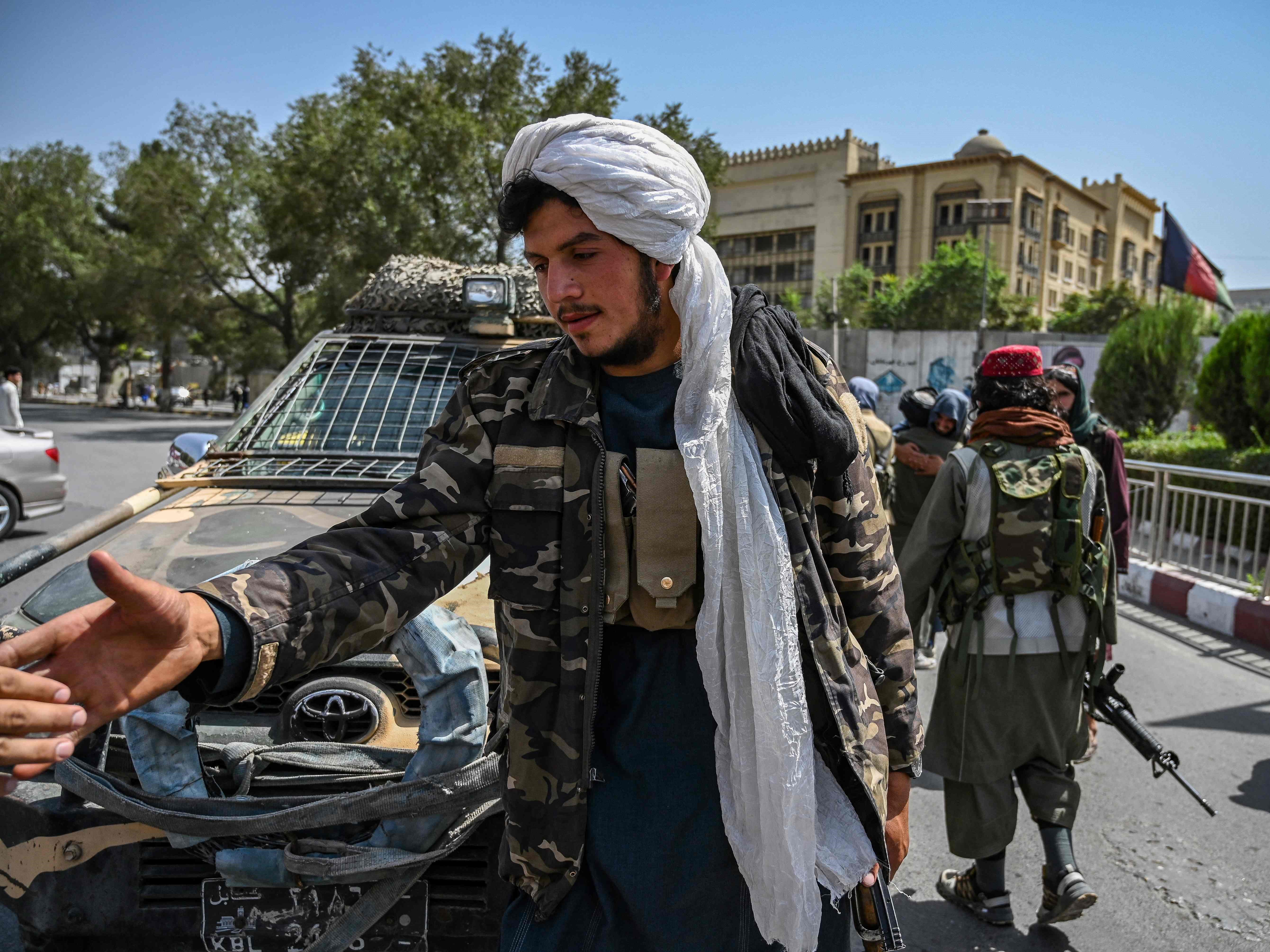 Pejuang Taliban berjaga di sepanjang jalan di Massoud Square di Kabul pada Senin (16/8).