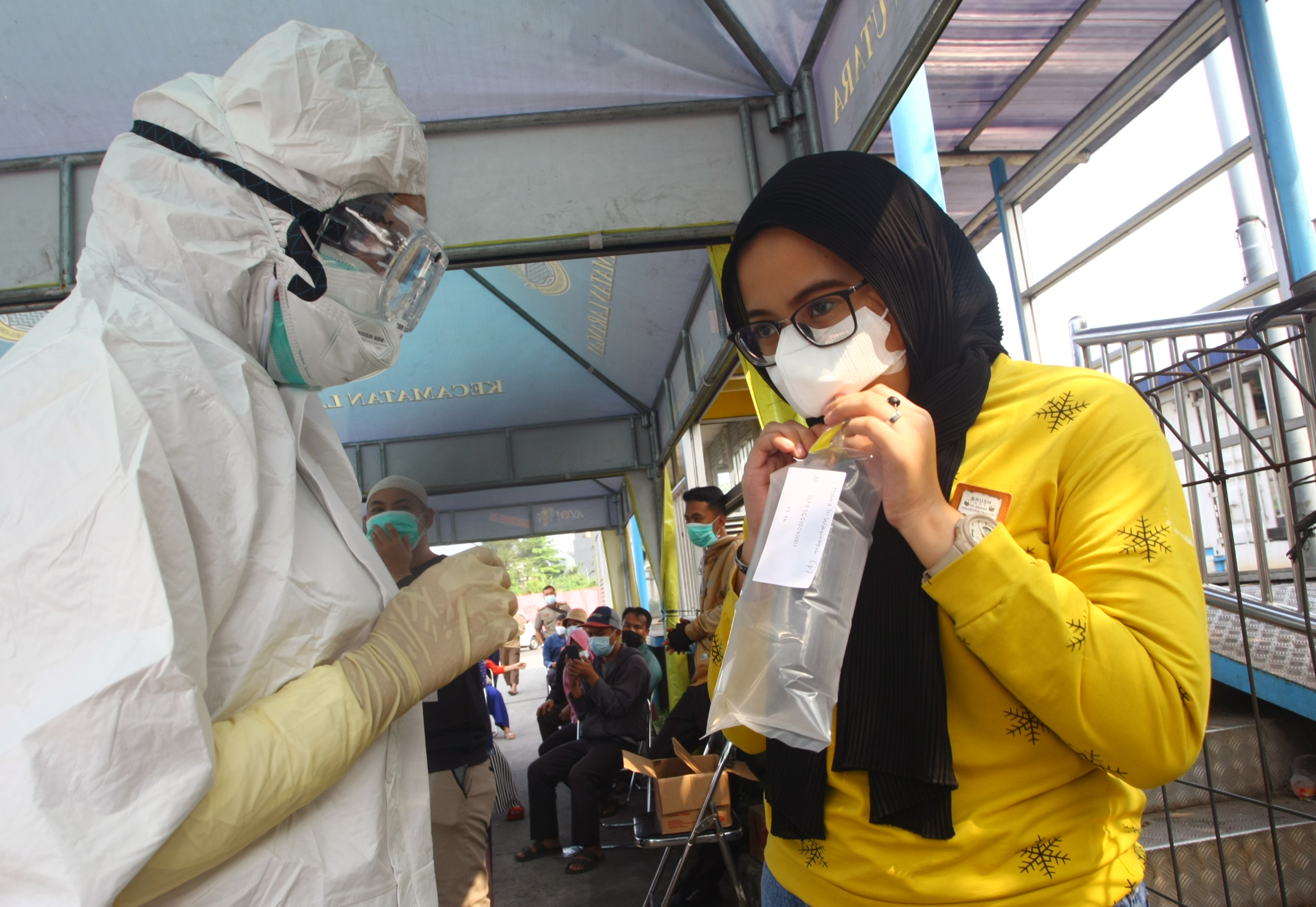 Petugas membantu calon penumpang mengikuti tes GeNose 19, di Halte Bus Trans-Jakarta Koridor 13 Puri Beta, Larangan, Tangerang, Banten.