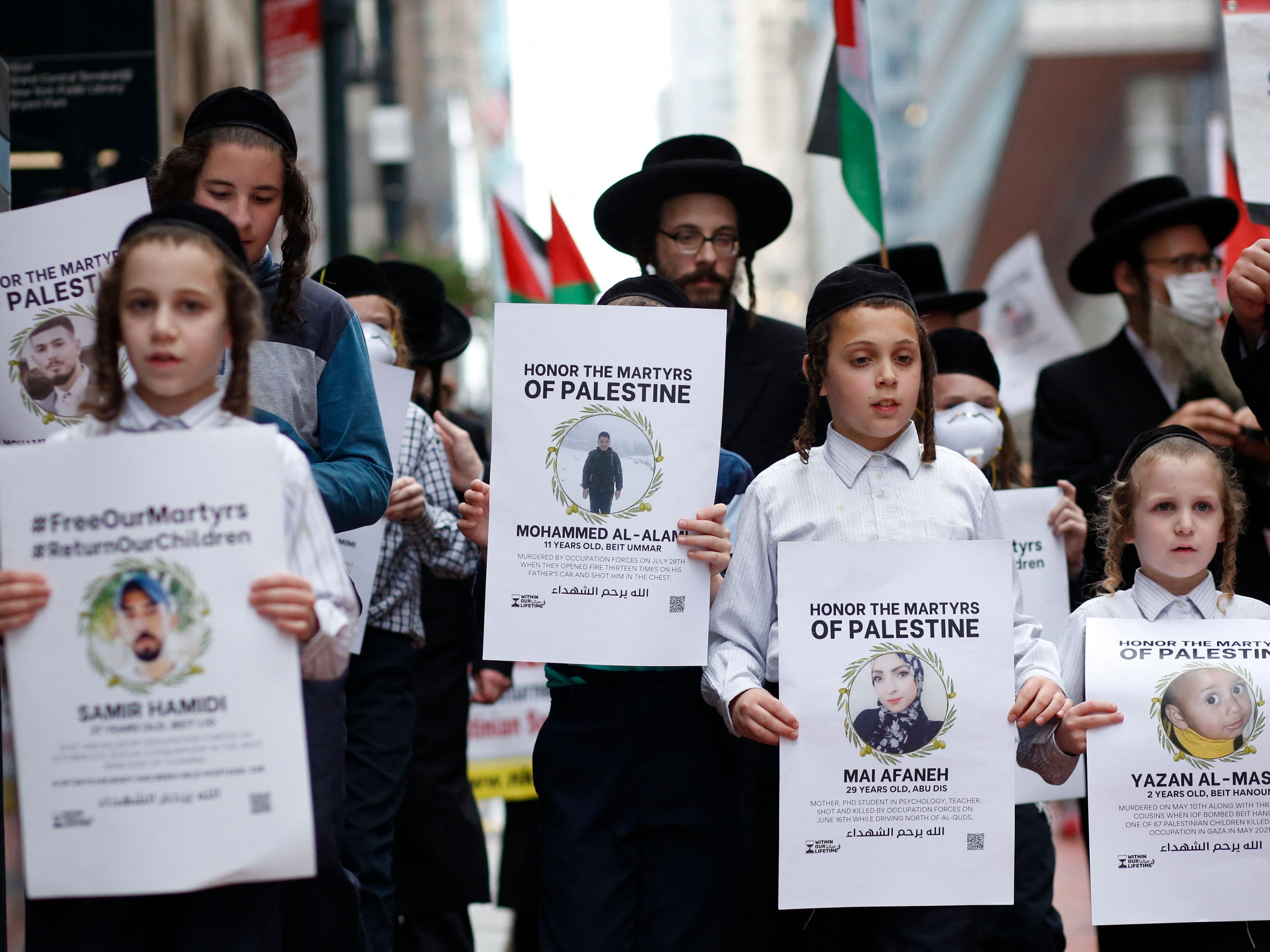Pemeluk Yahudi Ortodoks memegang poster saat pawai mendukung warga Palestina di New York, Minggu (29/8).