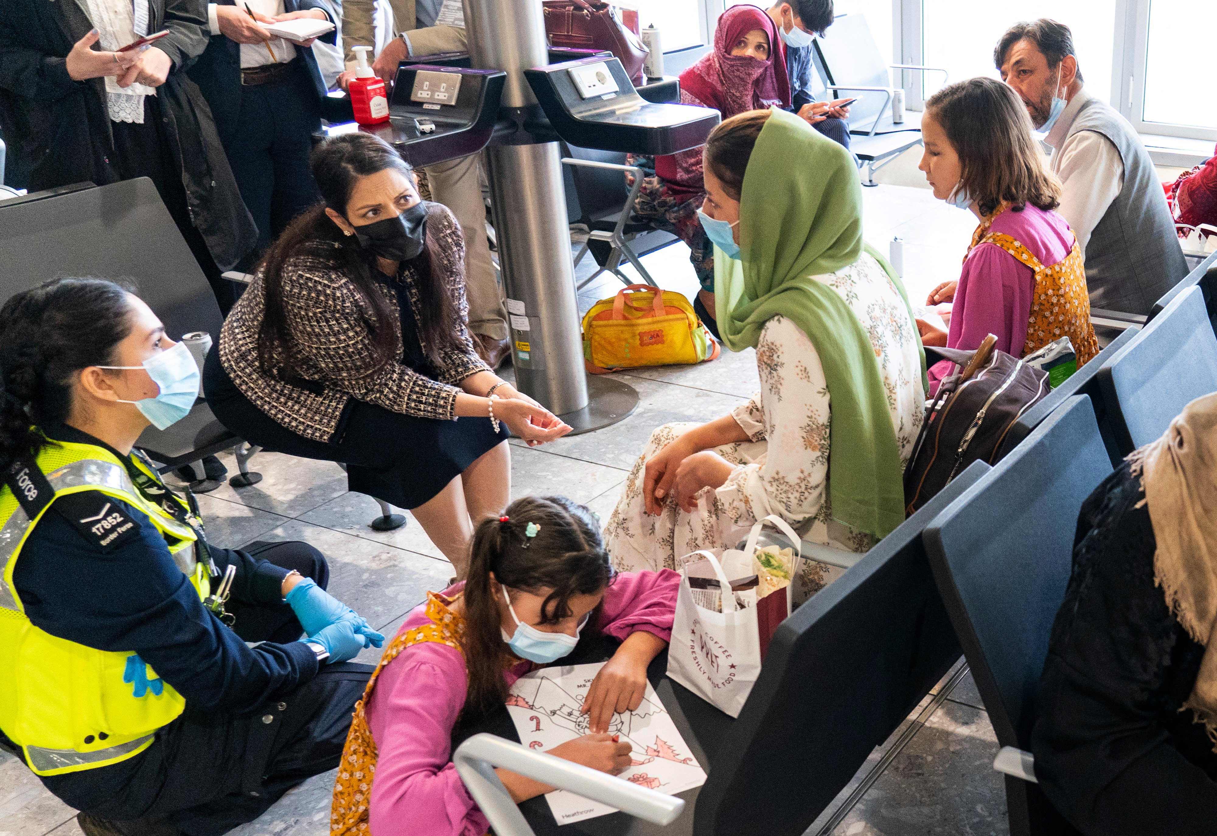 Pejabat pemerintahan Inggris berbicara dengan warga Afghanistan yang berhasil dievakuasi.