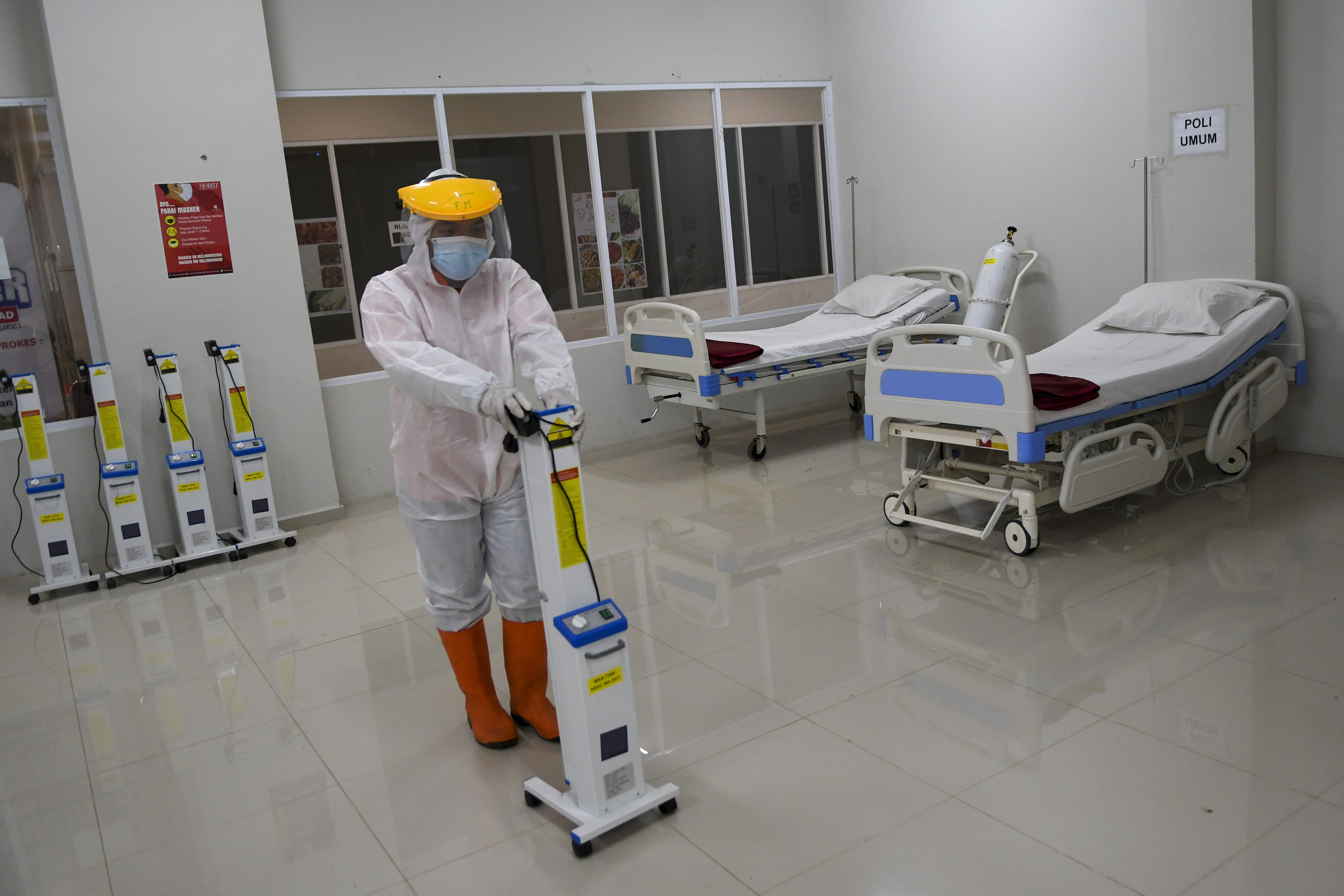 Petugas mendorong alat ultra violet saat menyiapkan ruangan perawatan di RSDC Wisma Atlet, Jakarta.