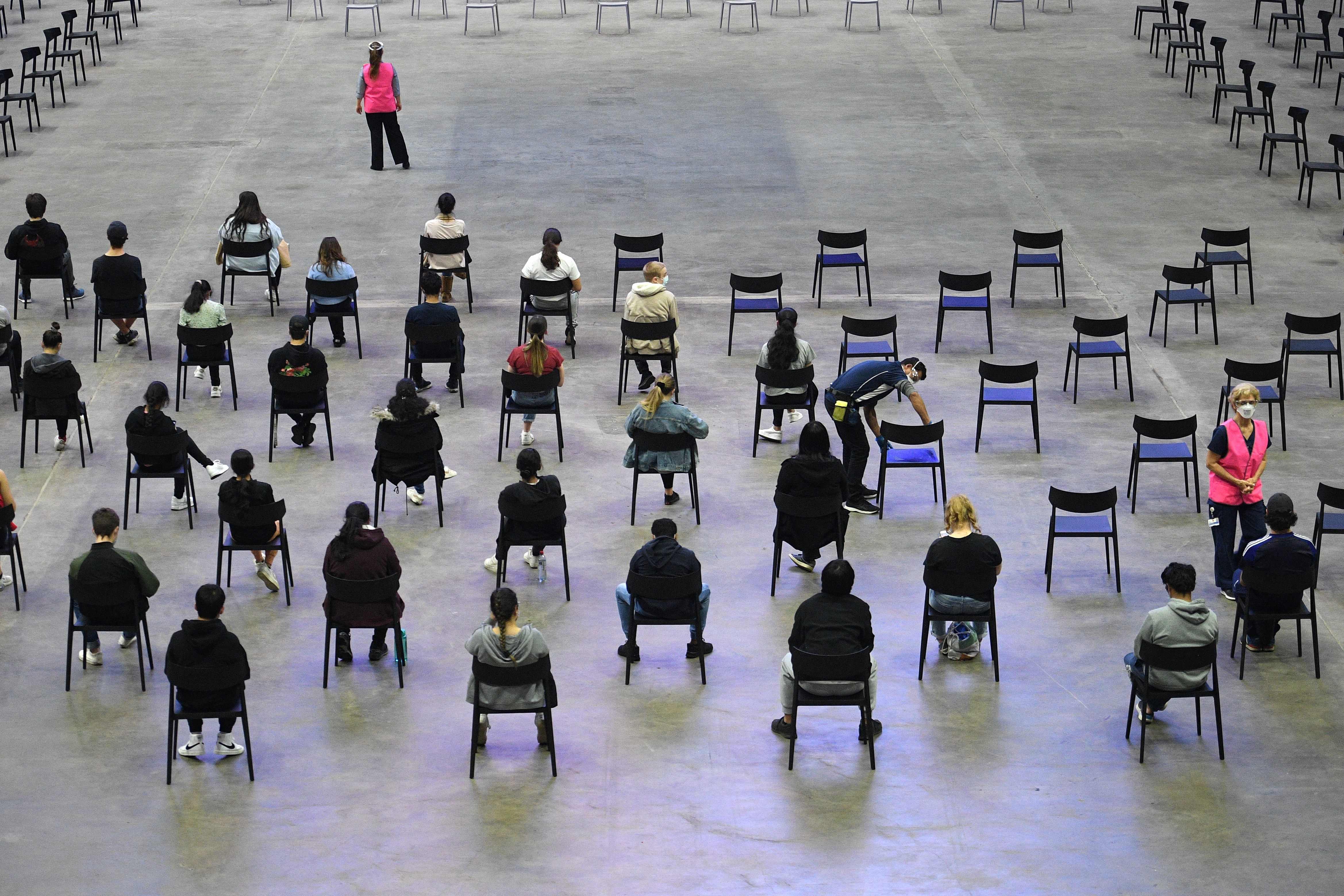 Sejumlah belajar menunggu giliran divaksin Covid-19 Pfizer di Kota Sydney, Australia, Senin (9/8).  