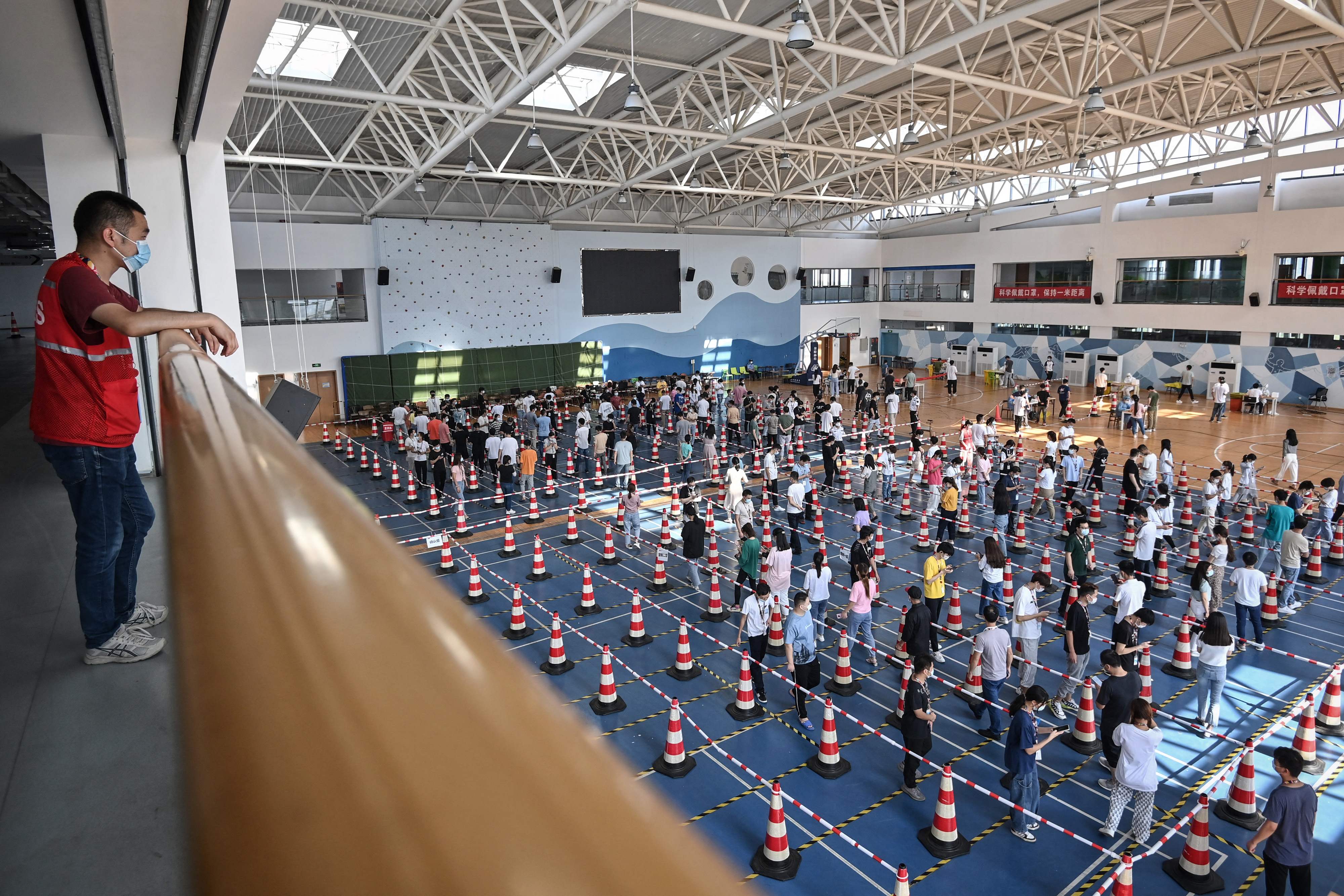 Warga mengantre untuk tes virus corona Covid-19 di gym sebuah perusahaan di Wuhan di provinsi Hubei tengah Tiongkok, Kamis (5/8)