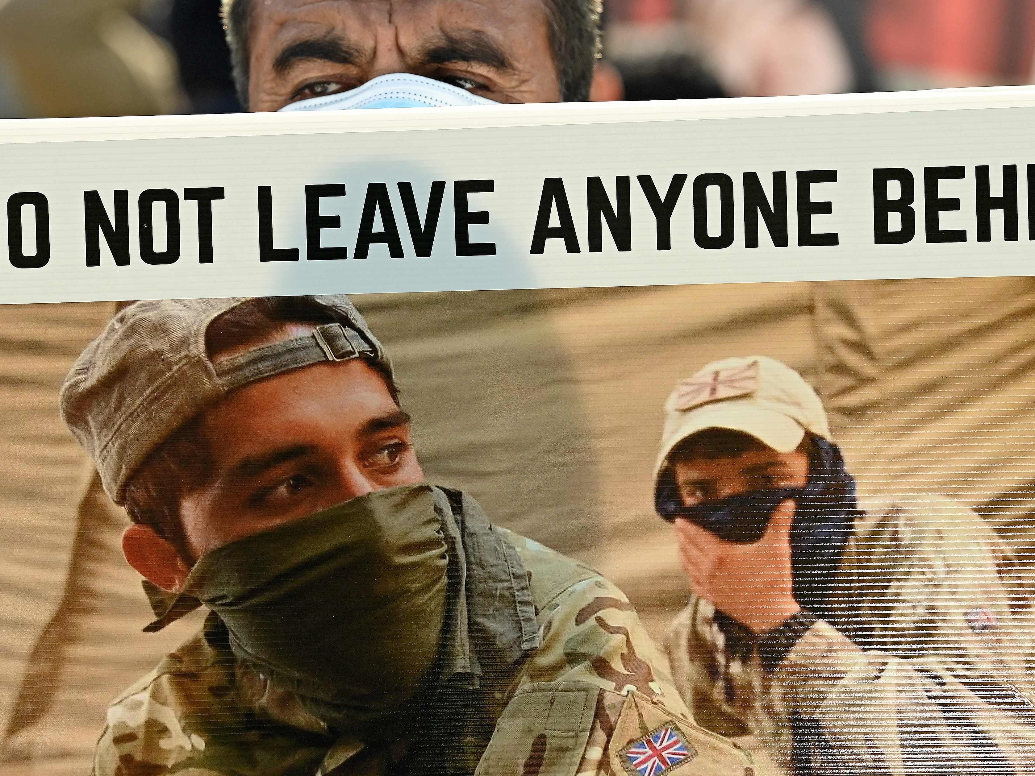 Demonstran memegang poster saat mereka memprotes di depan gedung parlemen, London, Inggris, Rabu (18/8).