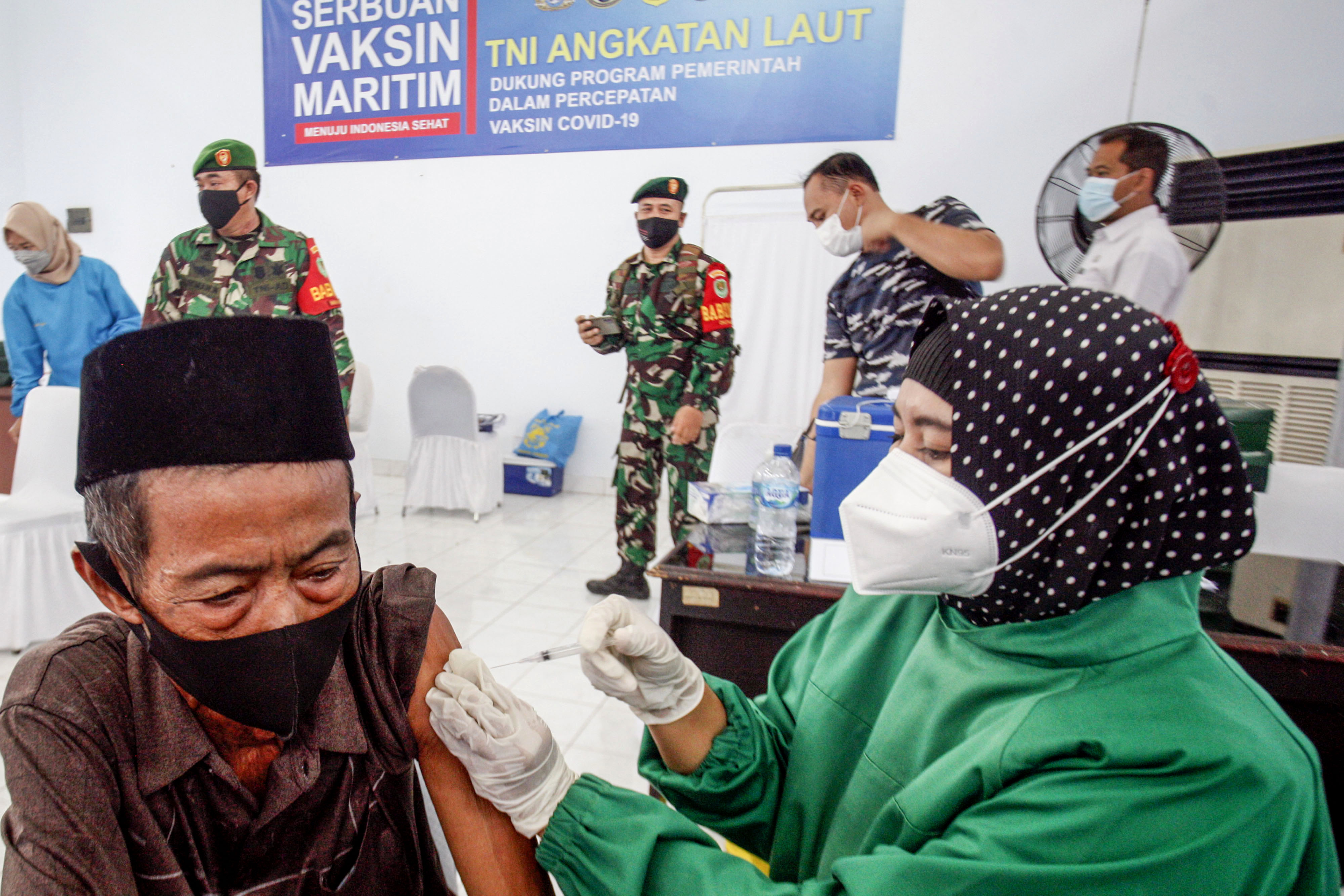 Petugas menyuntikan vaksin covid-19 kepada warga saat vaksinasi massal di Pemancar Radio TNI AL, Cariu, Kabupaten Bogor, Jawa Barat.