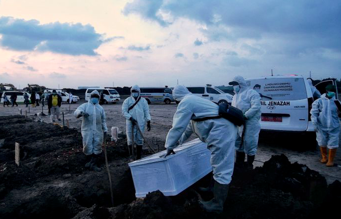 Petugas mengangkat jenazah korban covid-19 untuk dimakamkan di TPU Rorotan, Jakarta Utara, Minggu (27/6)