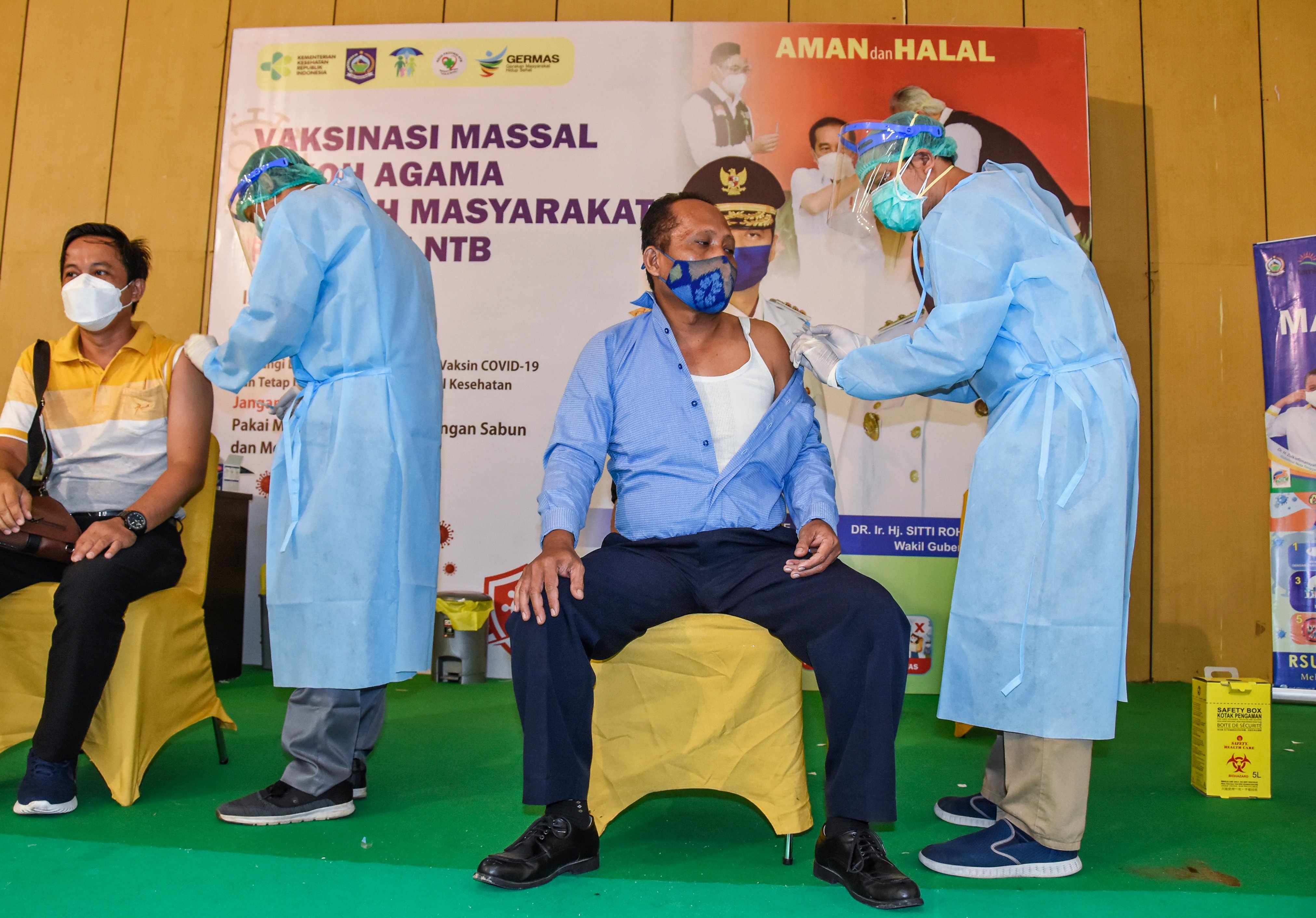 VAKSINASI COVID-19 SECARA MASSAL: Petugas kesehatan menyuntikkan vaksin covid-19 tahap pertama ke tokoh masyarakat di Islamic Center, NTB