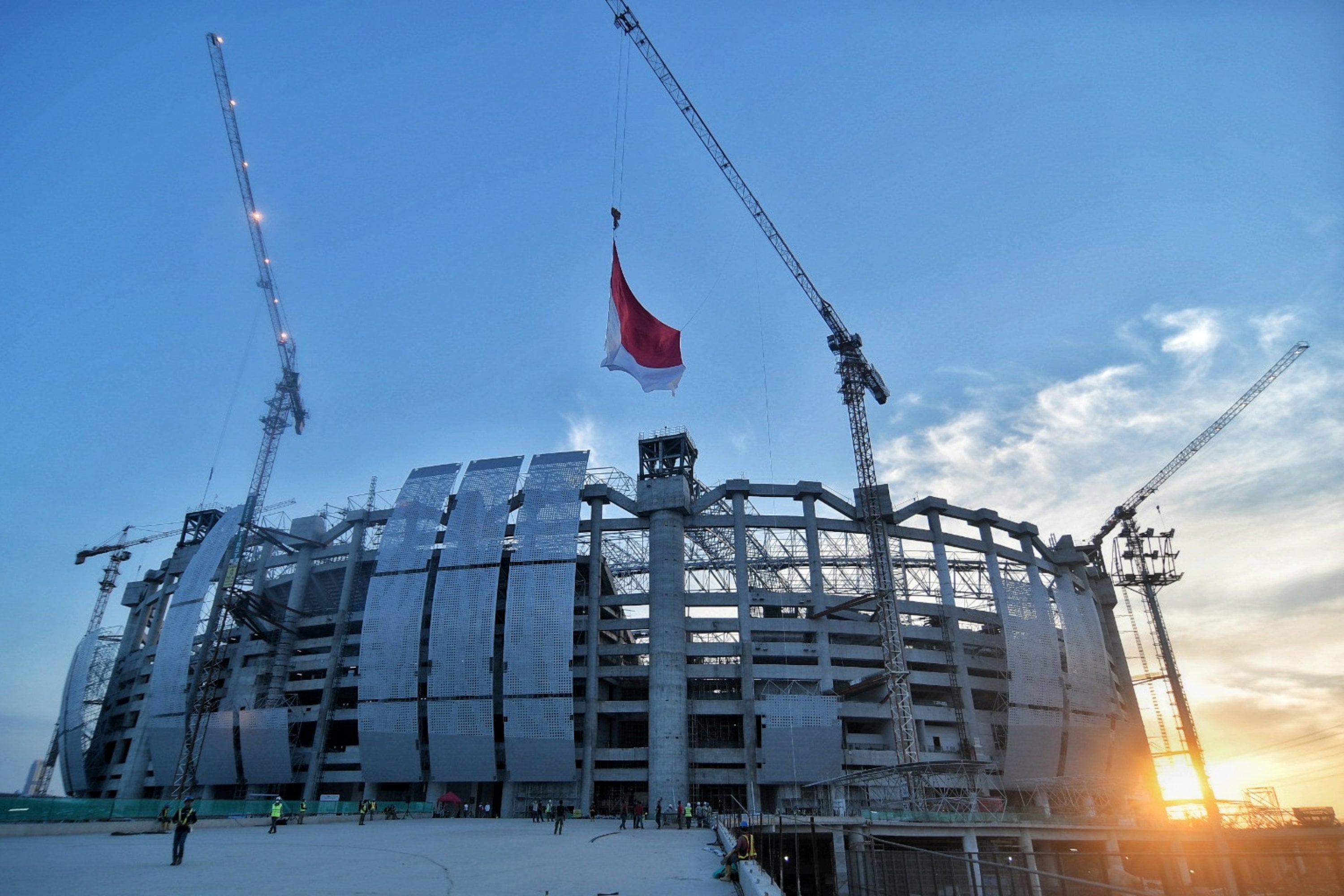 Pekerja berjalan keluar dari Jakarta International Stadium usai melakukan pembangunan di Papanggo, Jakarta Utara.