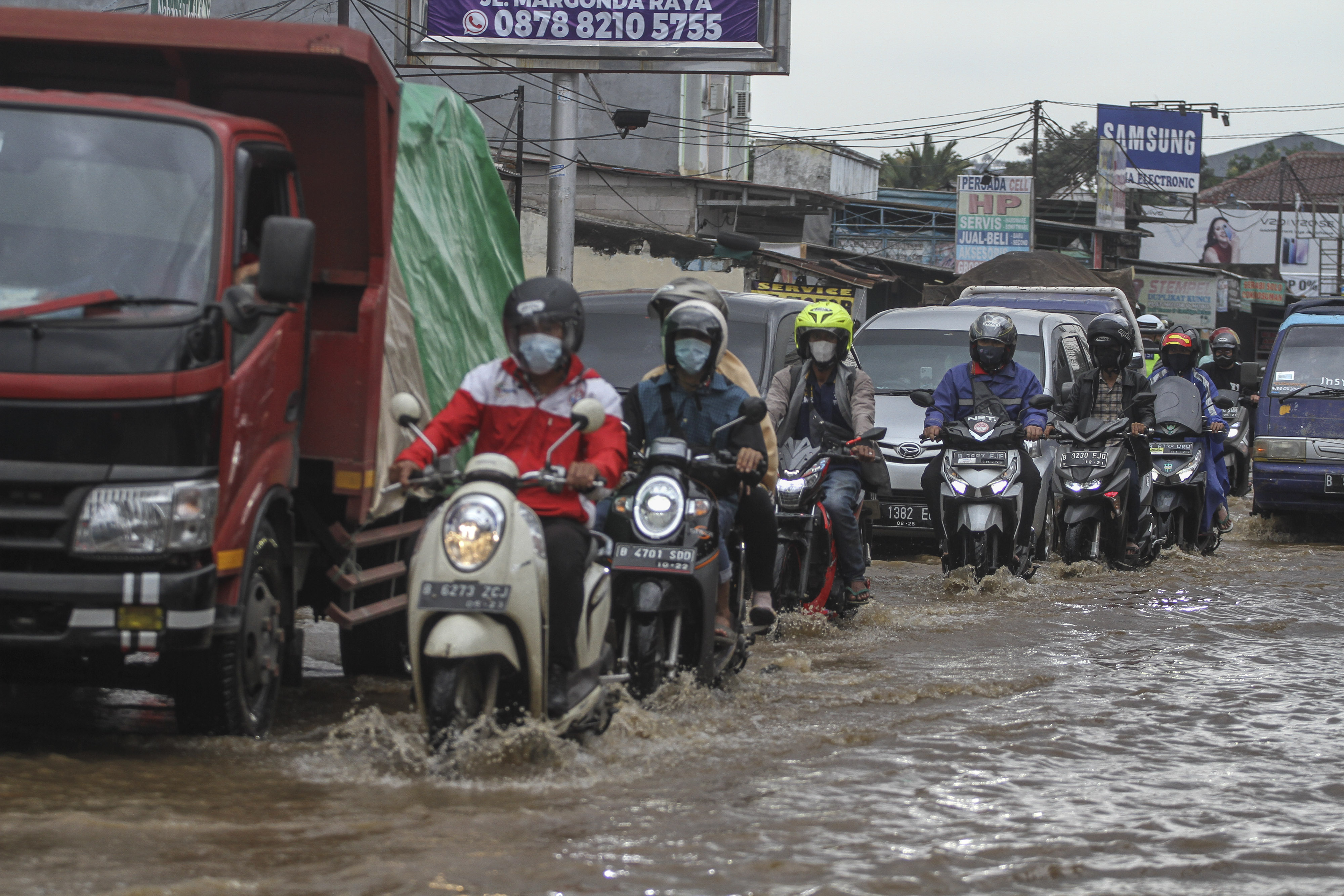 Sejumlah pengendara melintasi banjir di Kawasan Perempatan Mampang, Depok, Jawa Barat bulan Februari lalu.
