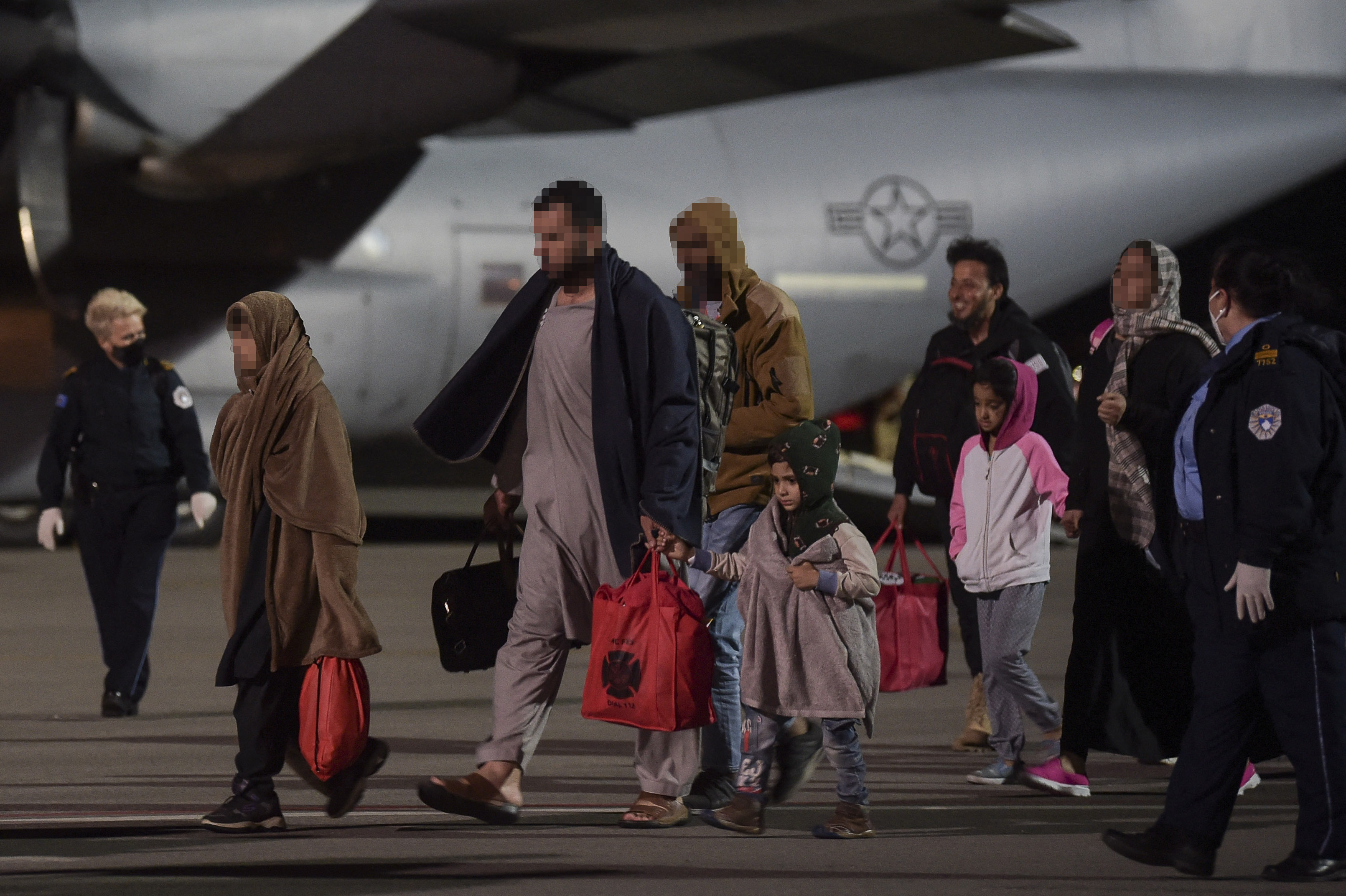 Para pengungsi Afghanistan turun dari pesawat militer AS di Bandara Internasional Pristina di Kosovo.