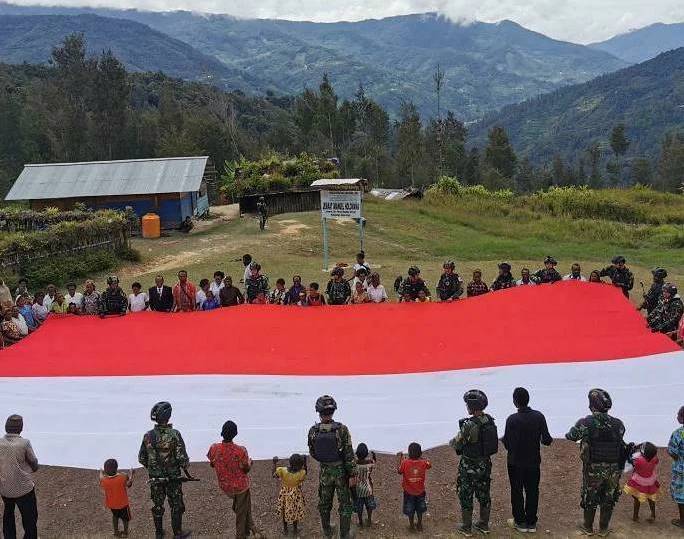 Satgas Pamtas Yonif Para Raider 501 Kostrad mengibarkan bendera merah putih raksasa, di Bilogai, Kabupaten Intan Jaya, Papua, Selasa (19/8)