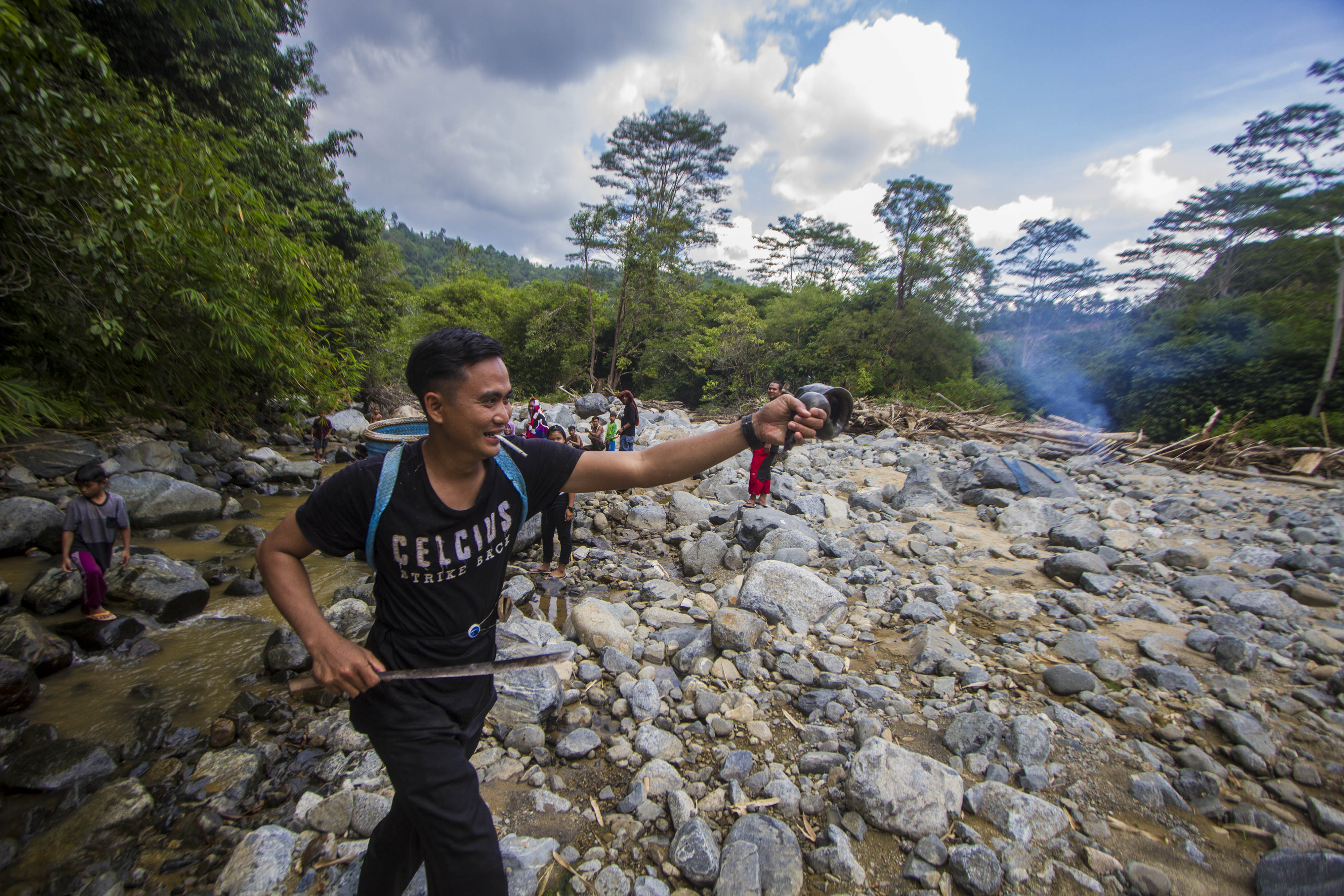 Masyarakat dayak Meratus mengangkat ikan yang didapatnya saat melakukan tradisi Maliu di Sungai Kapiyau, Kalimantan Selatan.