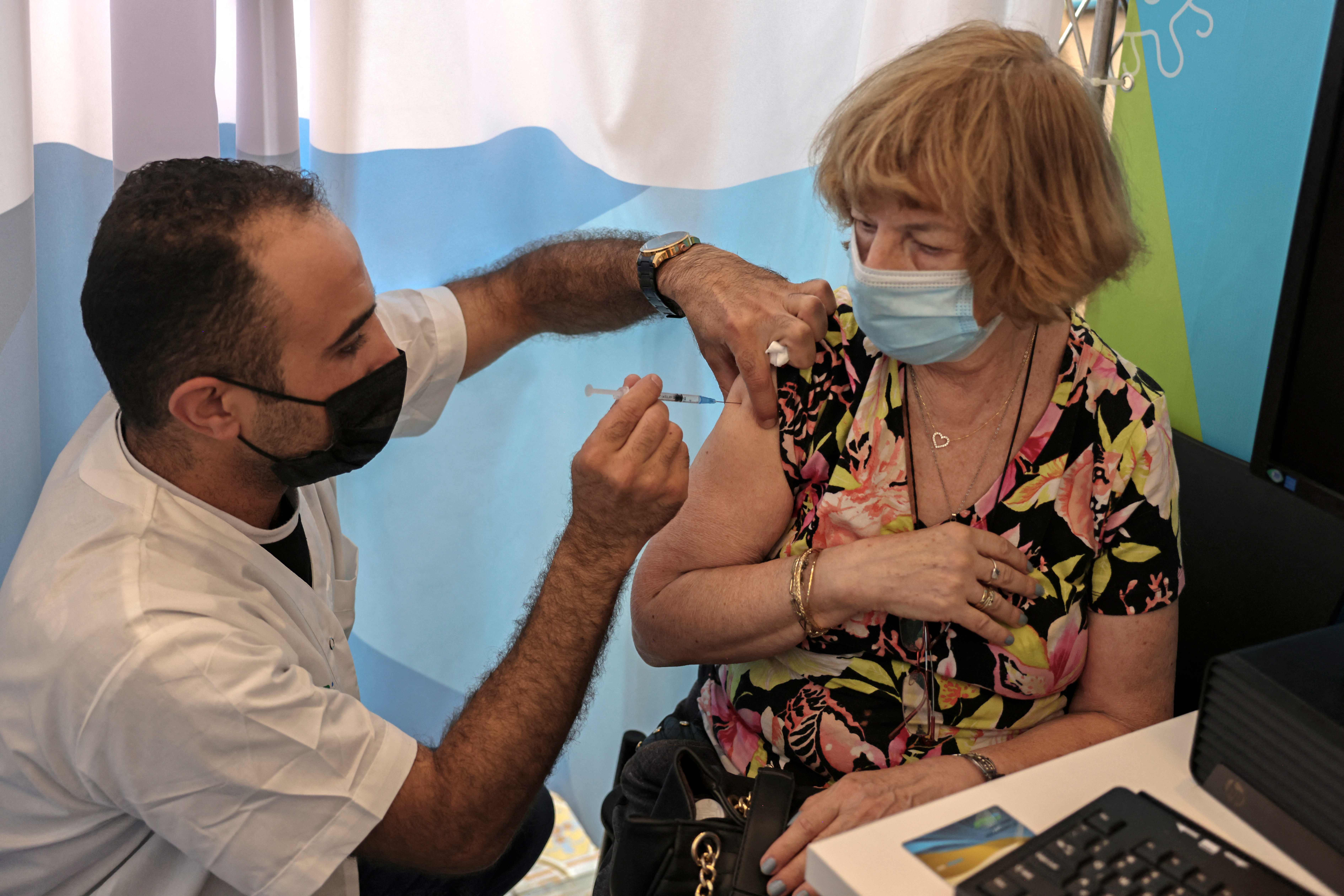 Petugas medis menyuntikn vaksin Covid-19 Pfizer-BioNTech kepada warga di Cinema City, Jerusalem, Minggu (8/8). 