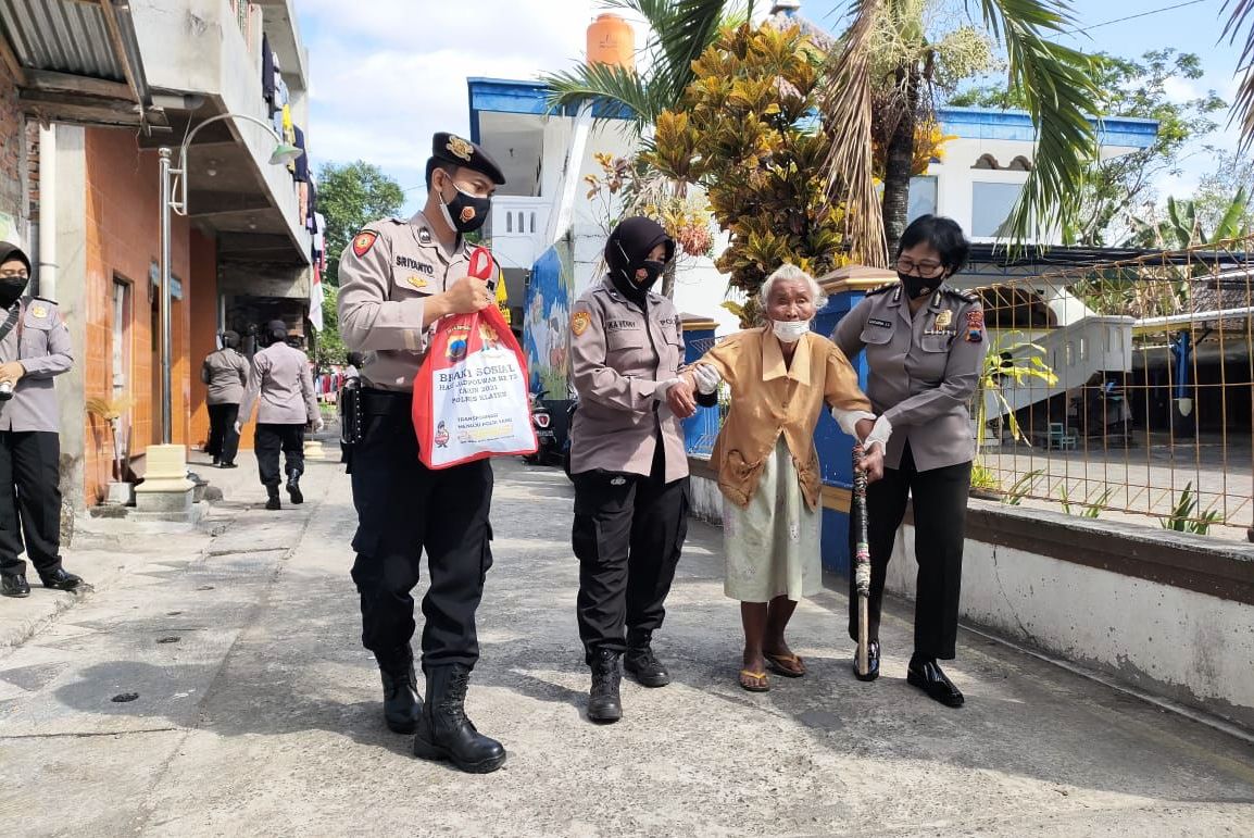  Warga duafa dituntun anggota Polwan saat gelar bakti sosial menyambut HUT ke-73 Polwan di Klaten.