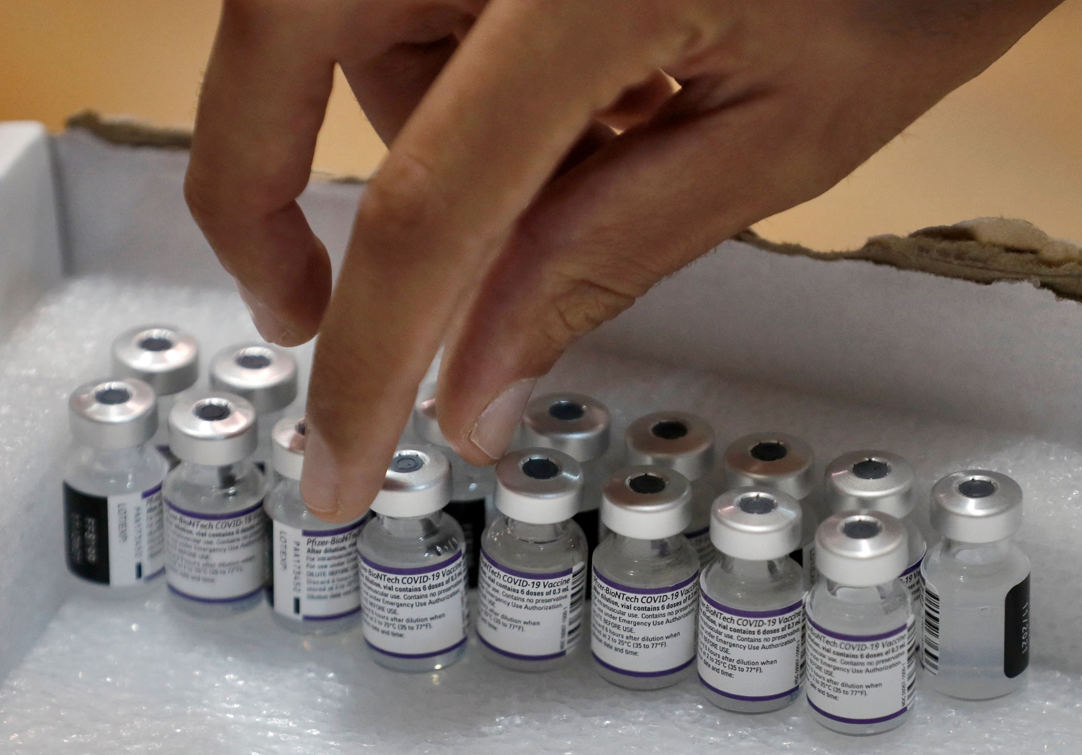 Seorang nakes mengambil botol vaksin covid-19 Pfizer-BioNTech di Holon, Israel.