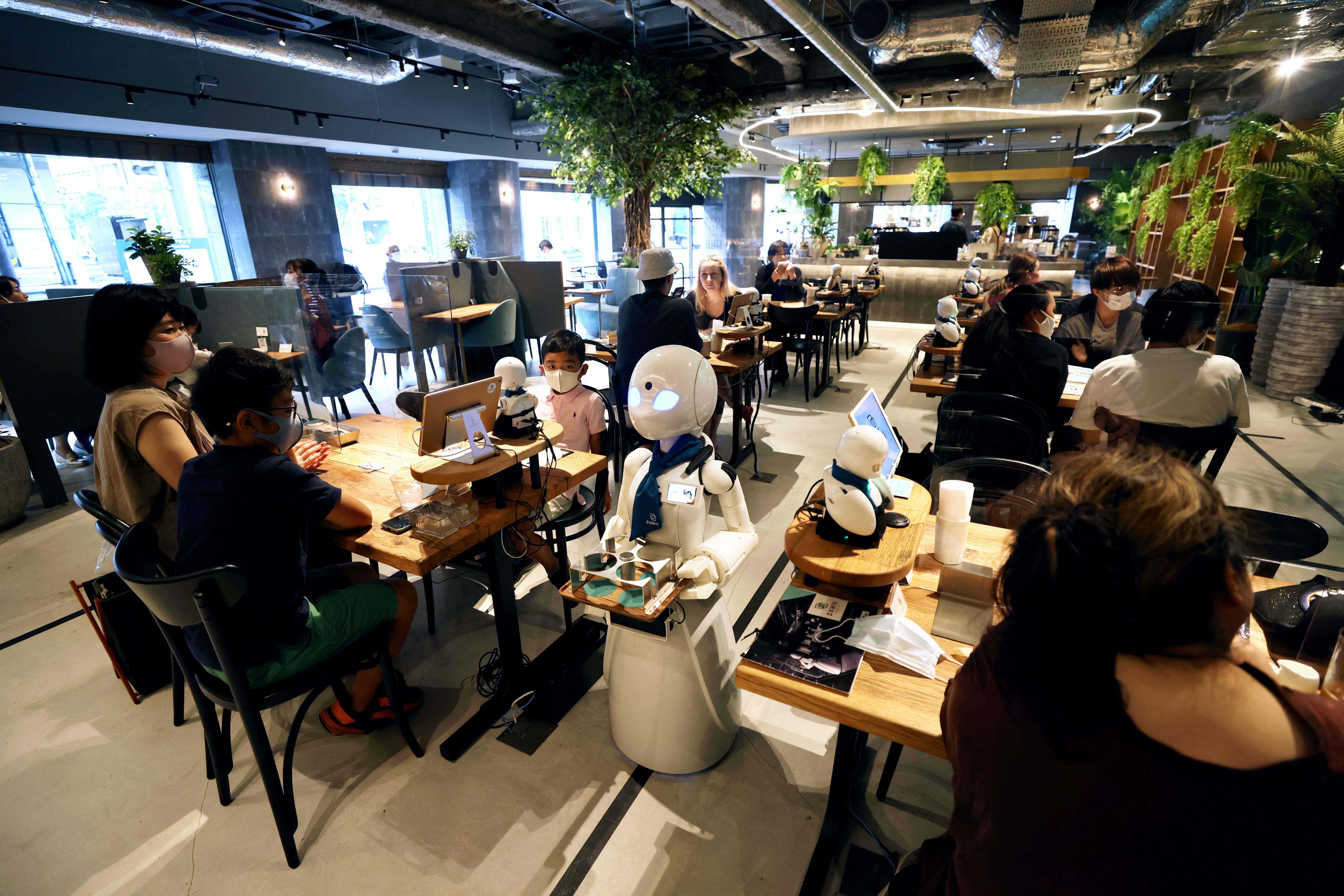 Robot humanoid sedang mengantarkan minuman yang dipesan pengunjung Dawn Cafe di Tokyo.
