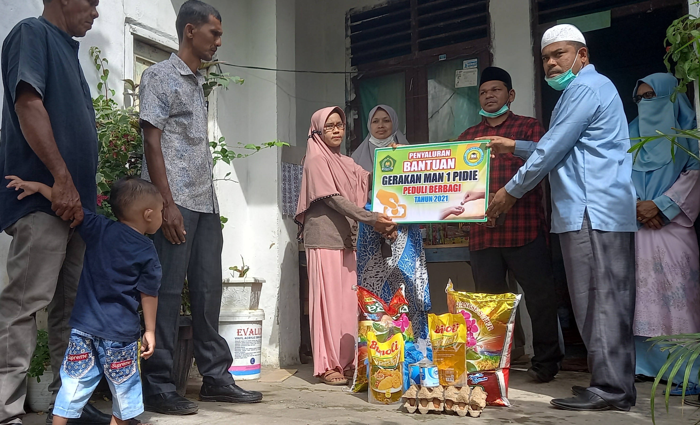 Penyerahan bantuan dana dan bahan pokok dari program peduli berbagi MAN 1 Sigli oleh Kepala MAN 1 Darwin Juwaini 