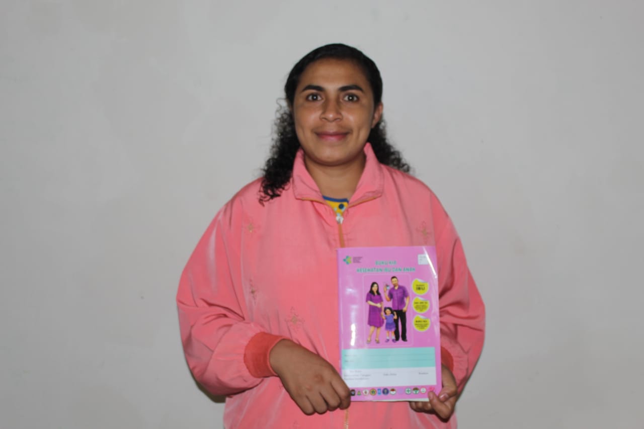 Yohana berpose sambil memperlihatkan buku KIA 2020  sebagai pendoman pemantuan kesehatan ibu dan anak
