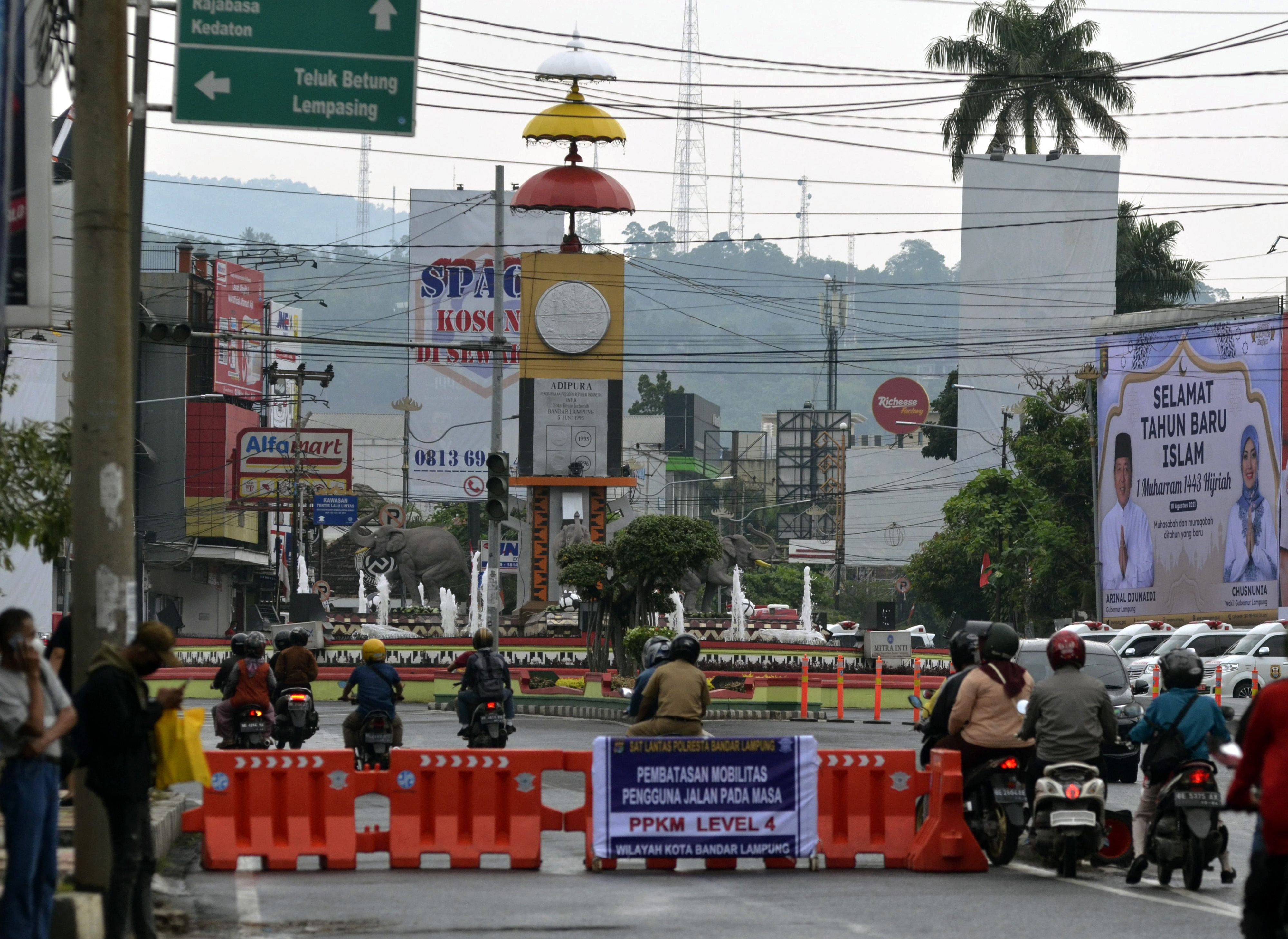 Sejumlah pengendara menerobos celah penyekatan jalan di Jenderal Sudirman saat masa PPKM Level 4 di Bandar Lampung, Lampung.
