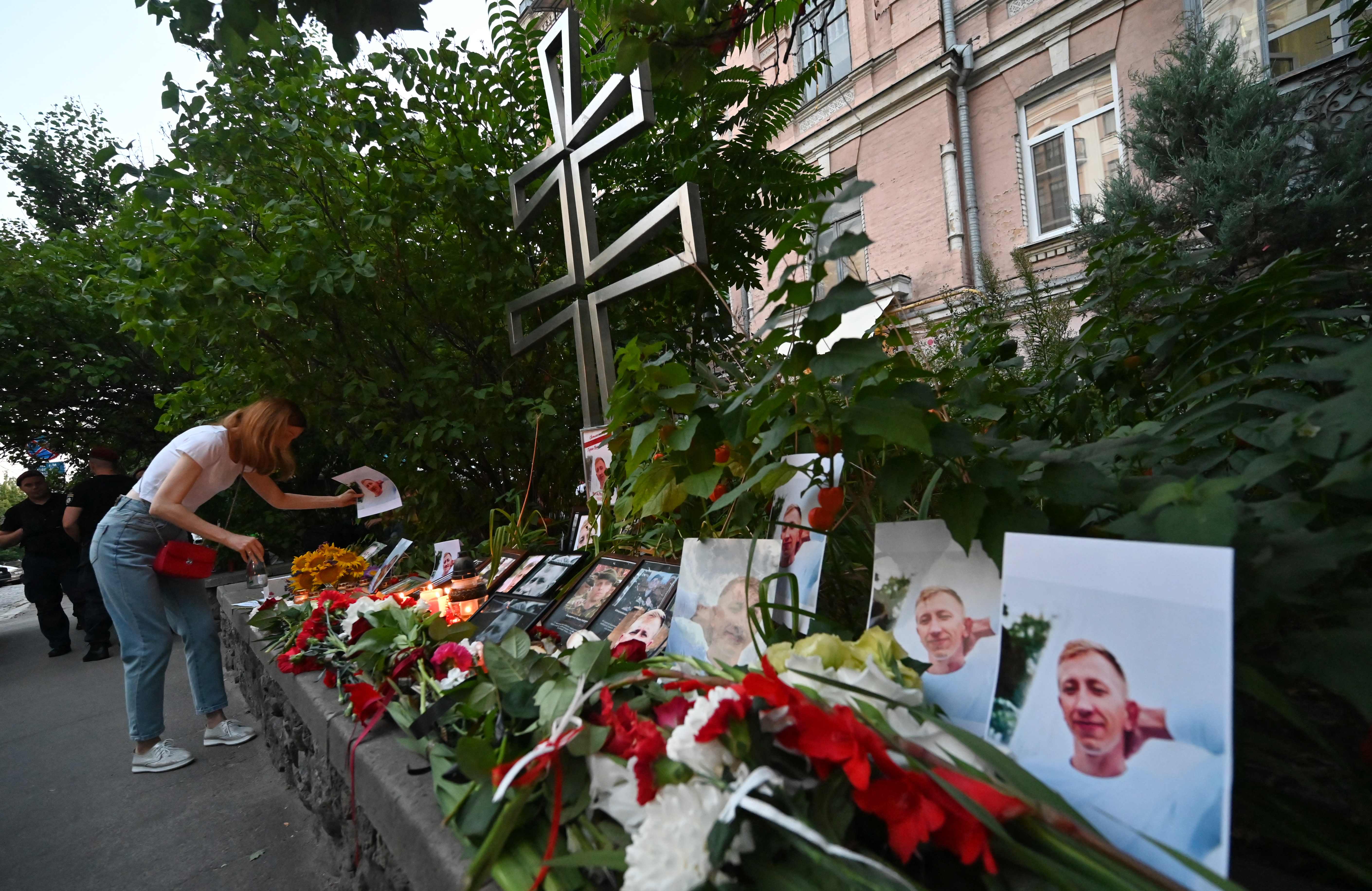 Seorang warga meletakkan foto di altar yang didirikan untuk mengenang Vitaly Shishov di depan Kedubes Belarus di Kiev.