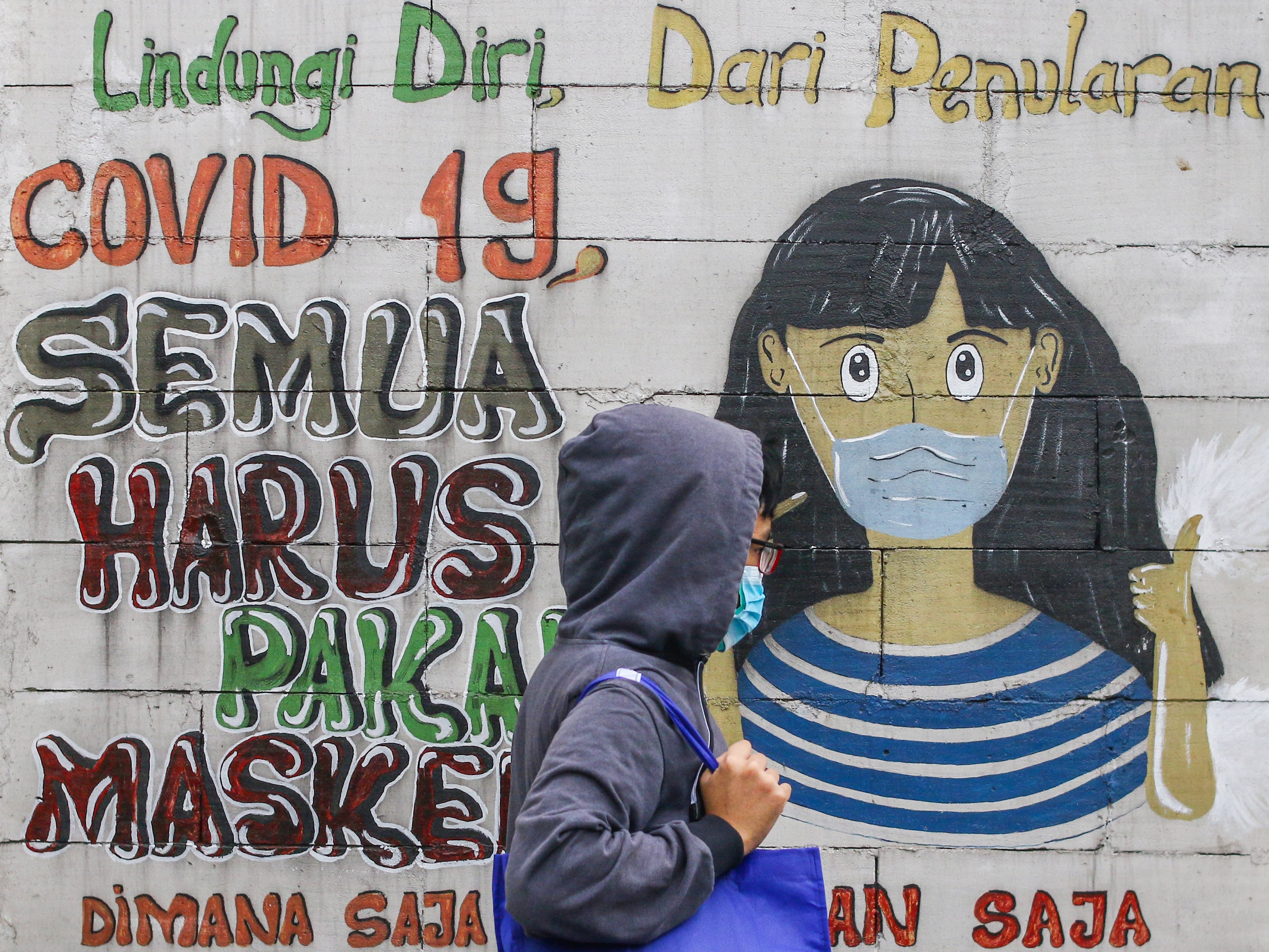 Warga melintas di dekat mural bertemakan covid-19 di Petamburan, Jakarta, Rabu (21/7).