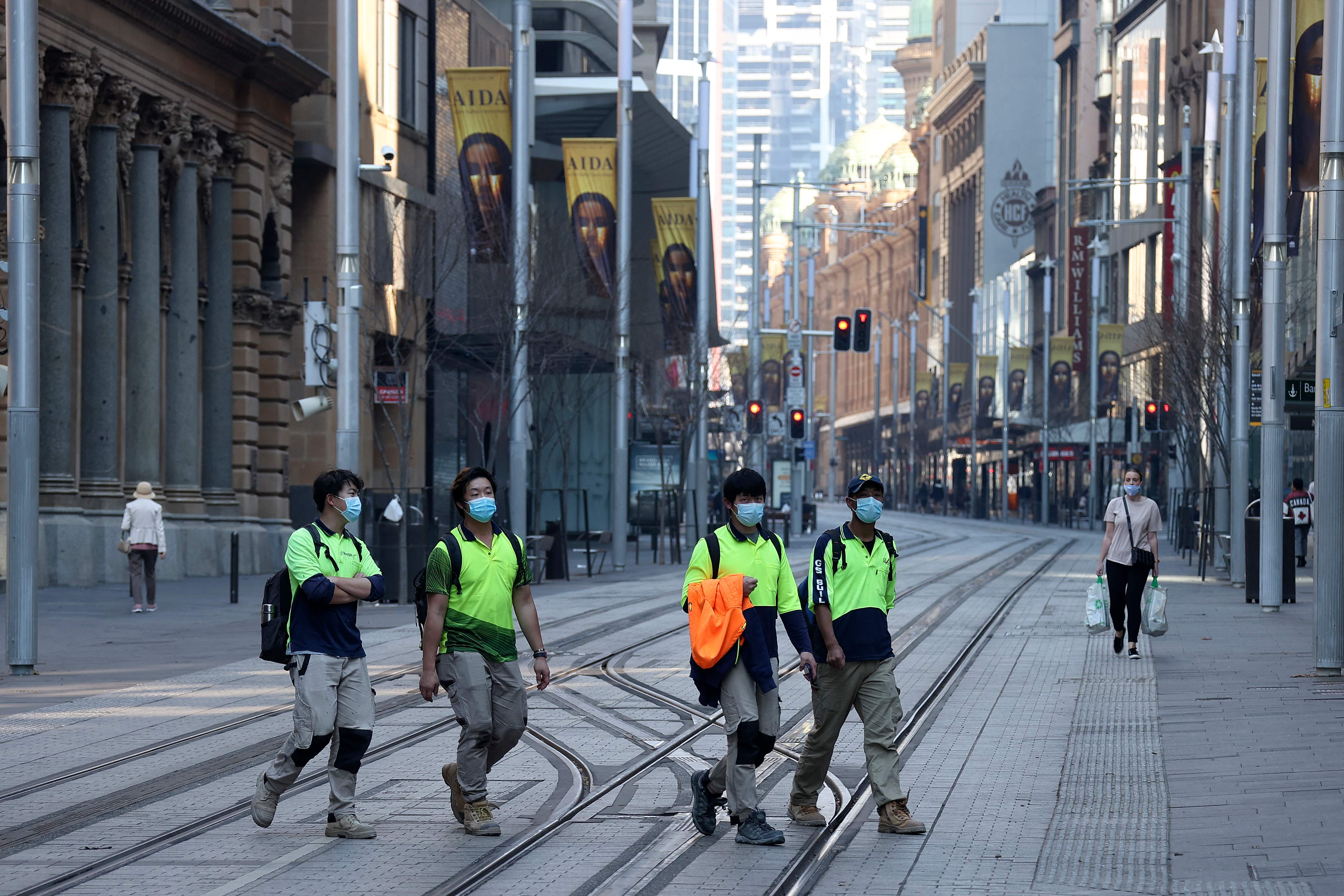 Sejumlah orang menyeberang di George Street, Sydney, Australia saat pemberlakuan lockdown covid-19.