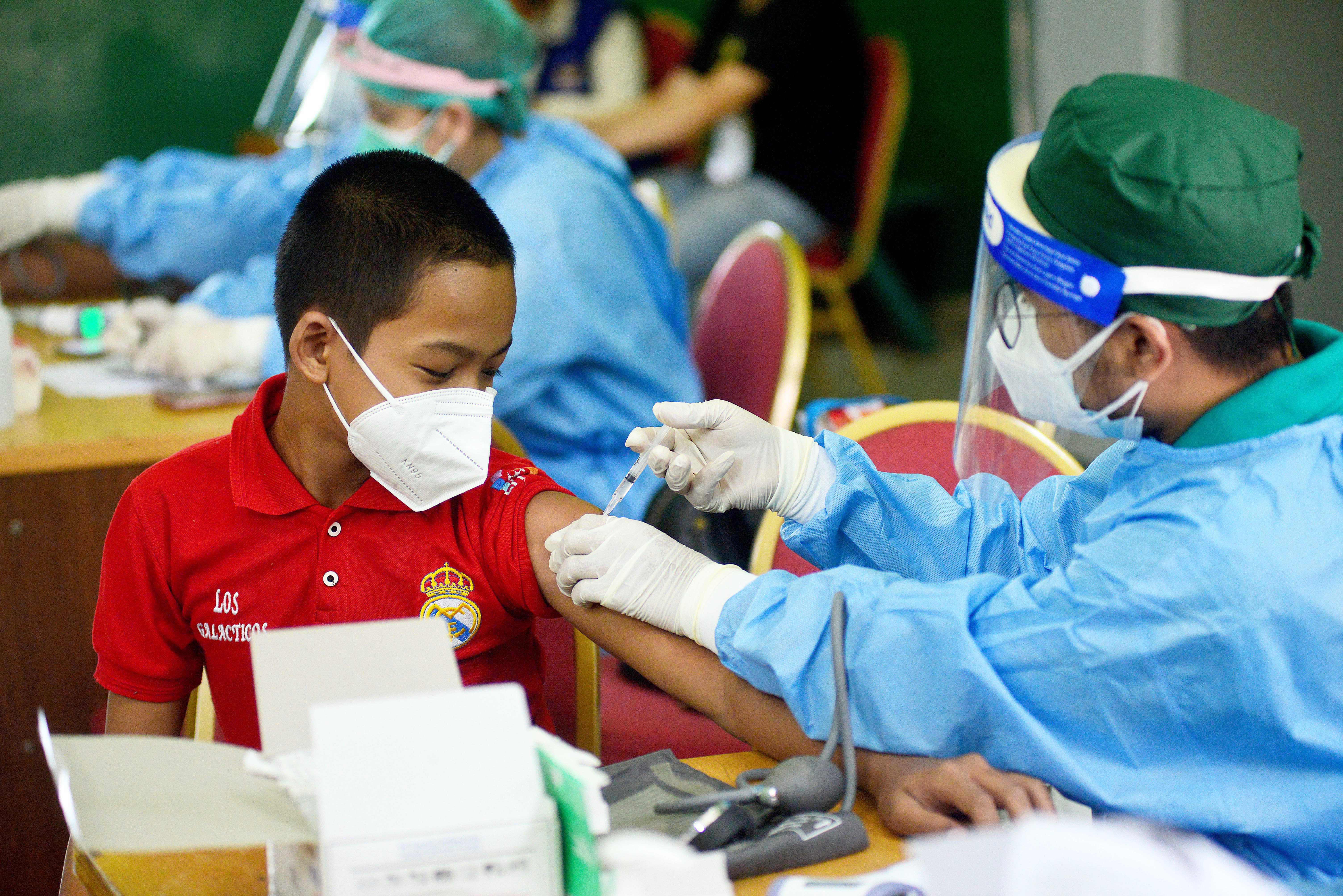 Nakes menyuntikkan vaksin covid-19 kepada anak-anak yang mengikuti program Vaksinasi di Gelanggang Remaja Pesanggarahan, Jakarta Selatan.