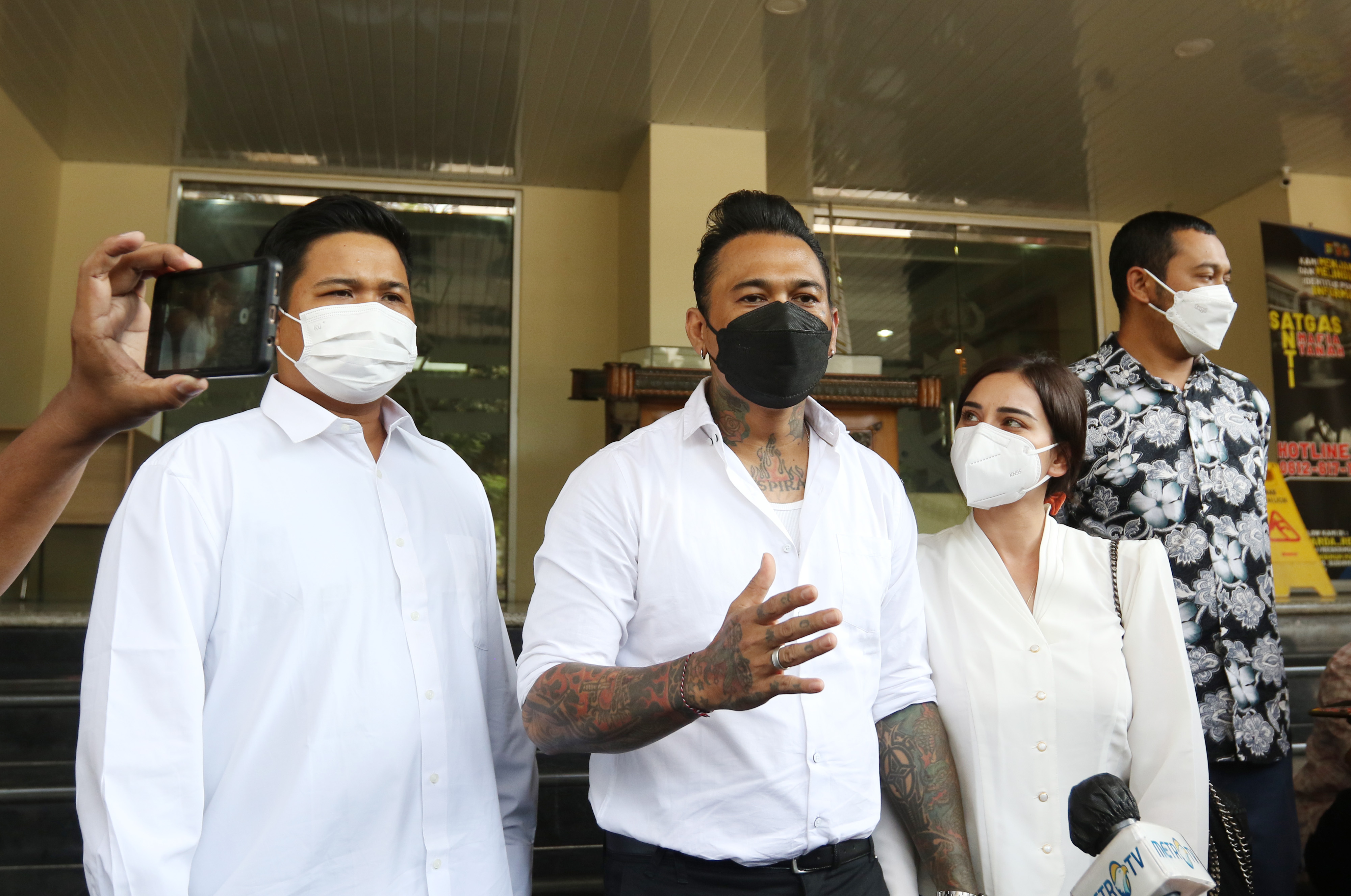 Musisi I Gede Ari Astina atau yang biasa dipanggil Jerinx (kiri) didampingi istrinya Nora Alexandra (tengah).