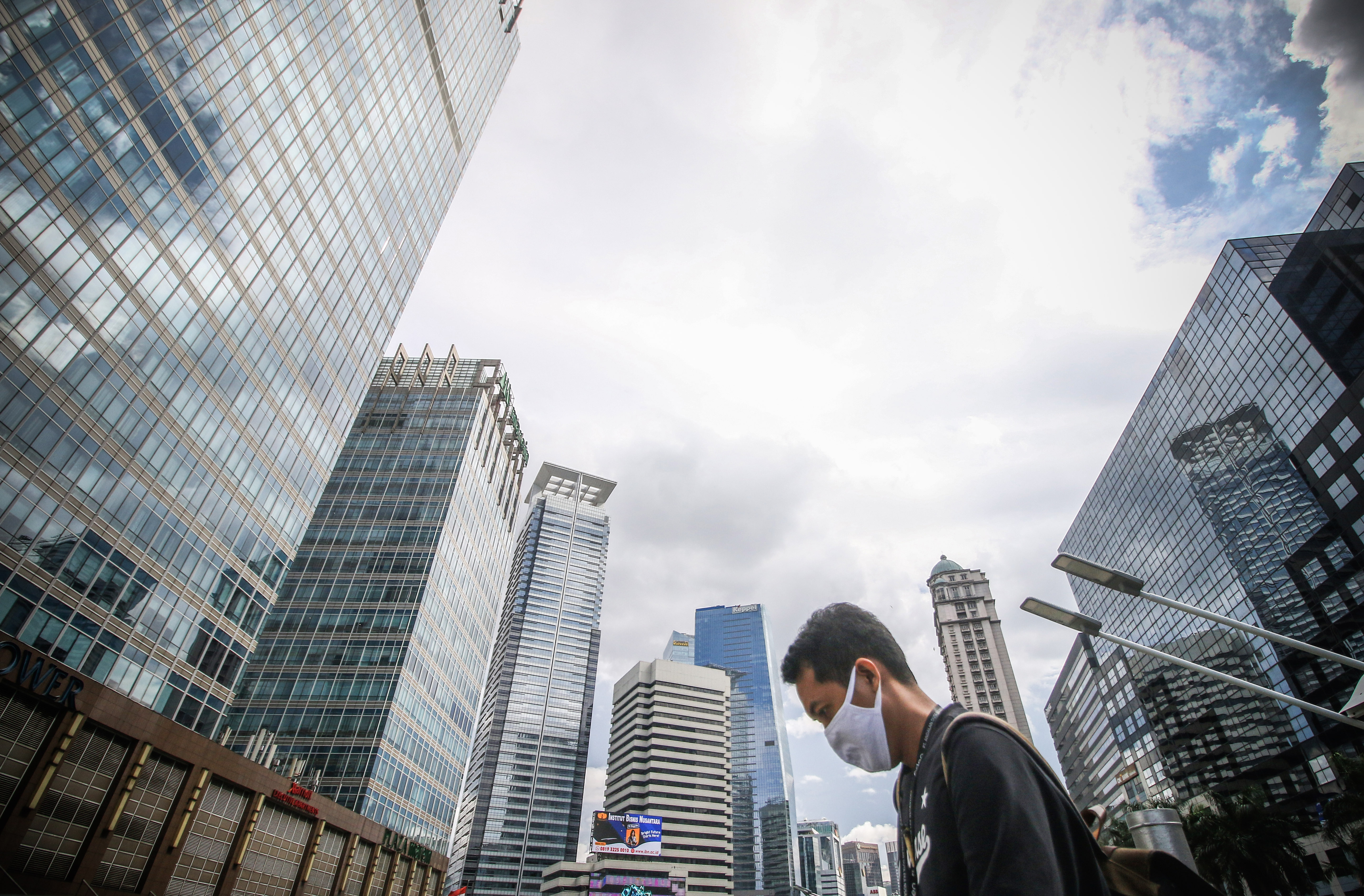 Warga berjalan dengan latar gedung bertingkat di Jalan Jenderal Sudirman Jakarta