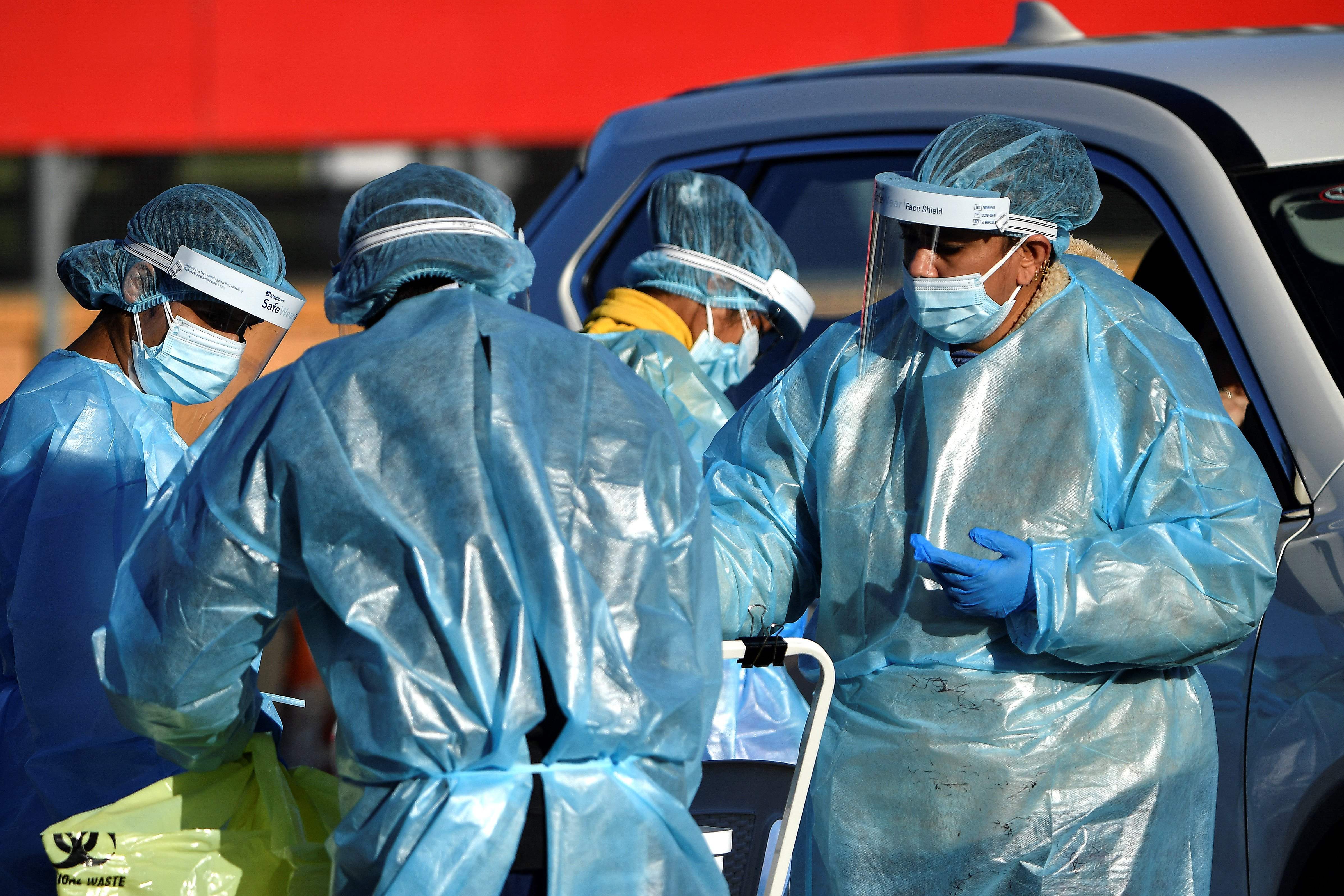 Petugas medis melakukan tes swab untuk mengetahui Covid-19 kepada warga secara drive-through di Kota Sydney, Australia, Rabu (4/8).