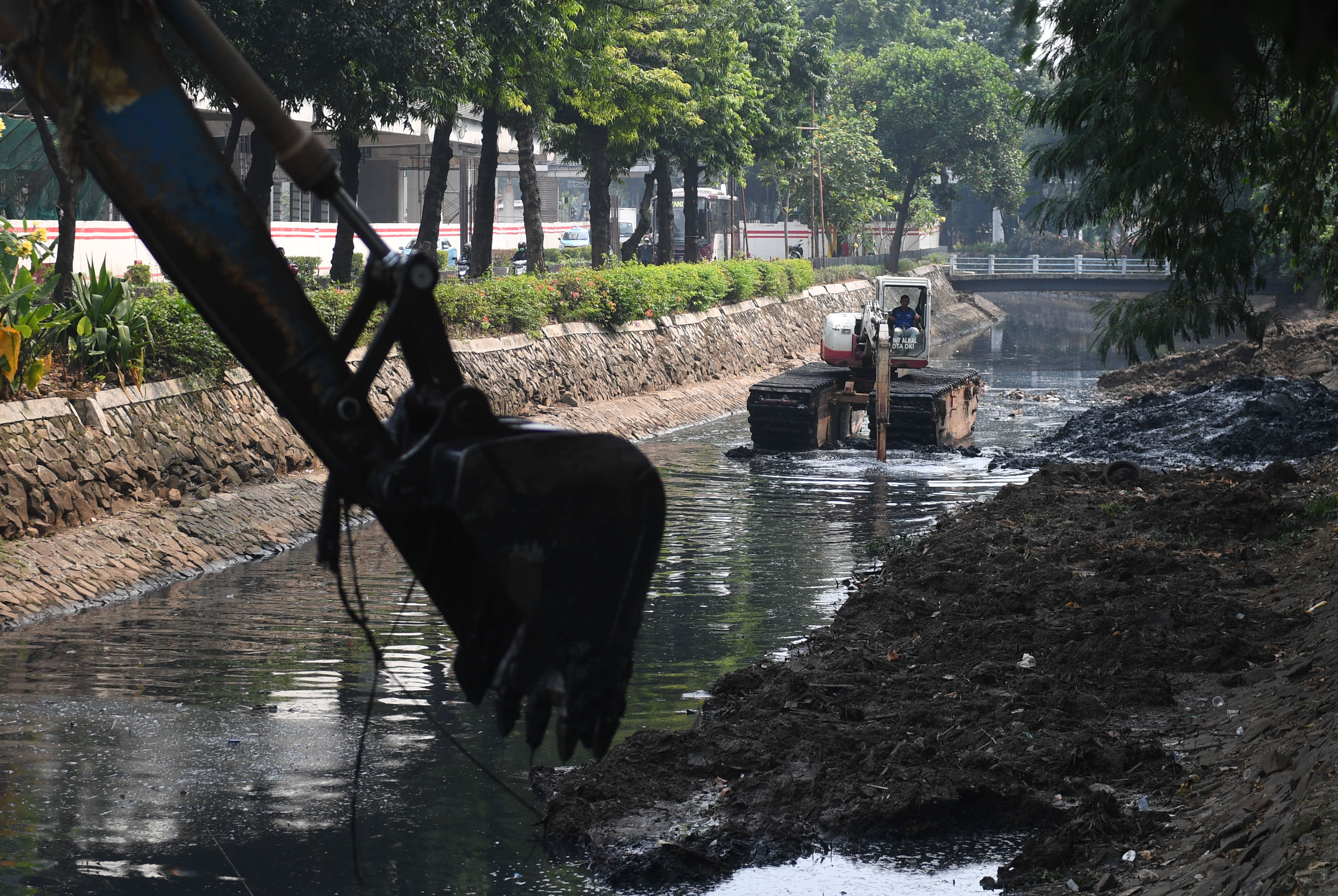  Petugas dengan menggunakan alat berat mengeruk endapan di Kali Cideng, Jakarta.
