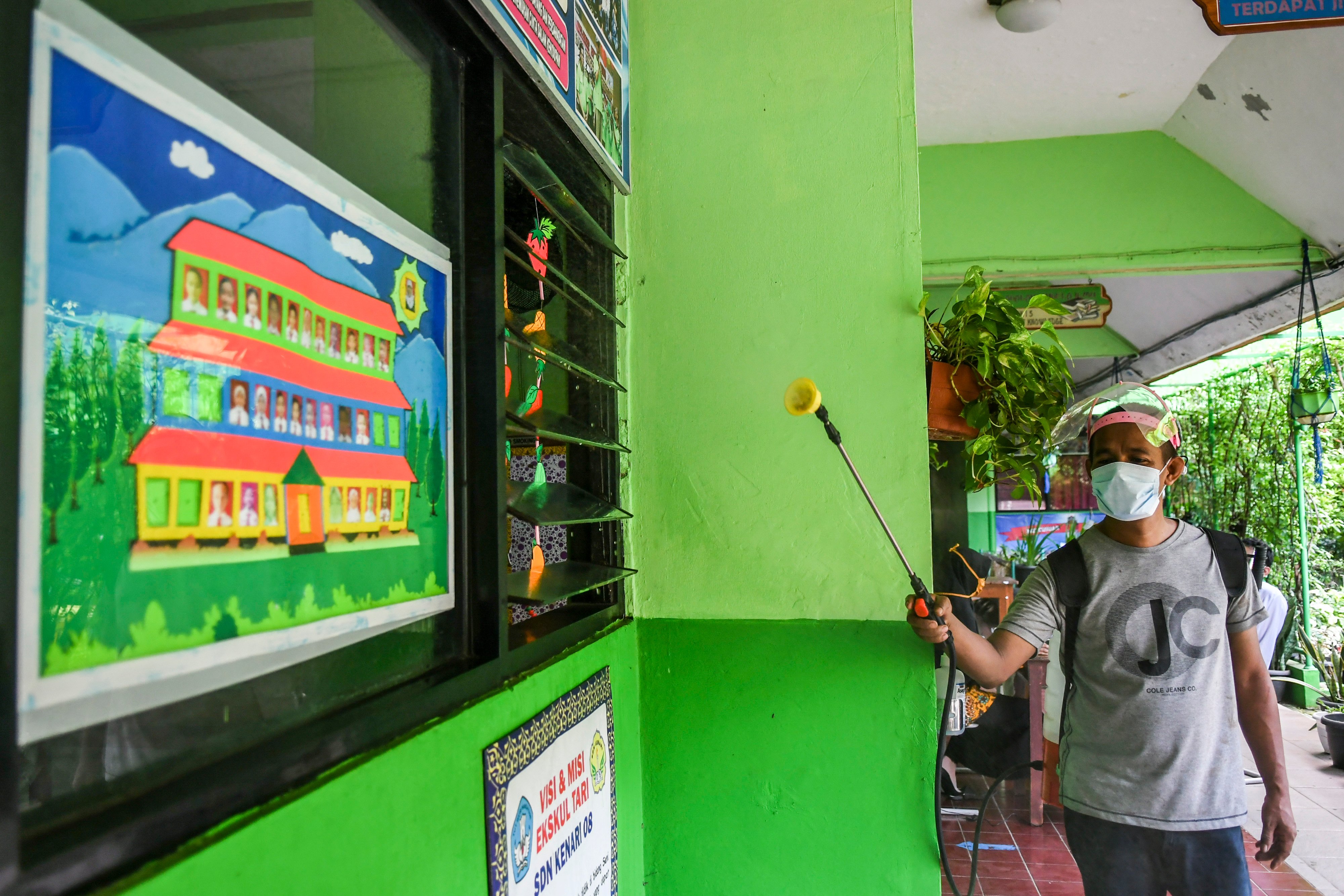 Petugas menyemprotkan disinfektan