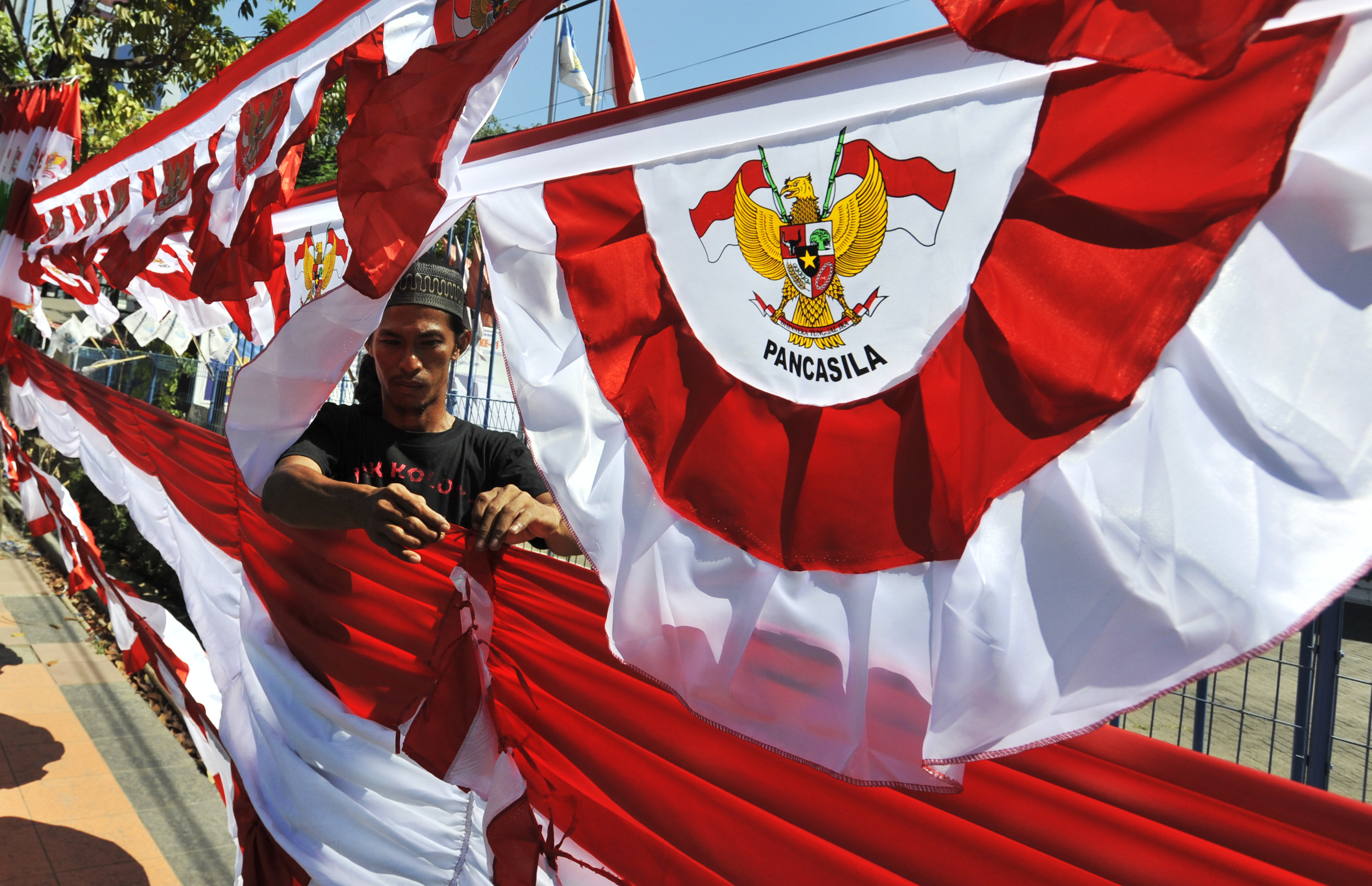 Penjual merapikan bendera dan umbul-umbul dagangannya di Makassar, Sulsel.