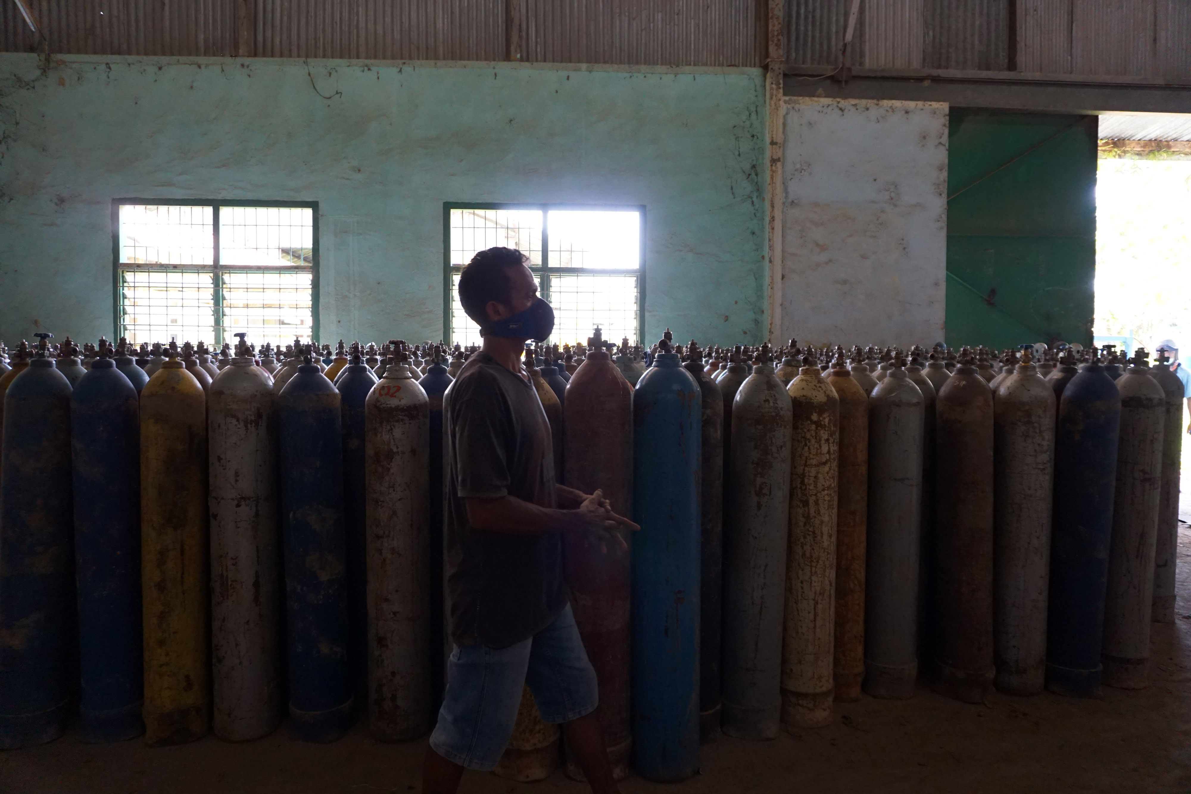 Karyawan PT Soronico Oxigen Factory berjalan di depan tabung oksigen di Kota Sorong, Papua Barat, Sabtu (31/7/2021).
