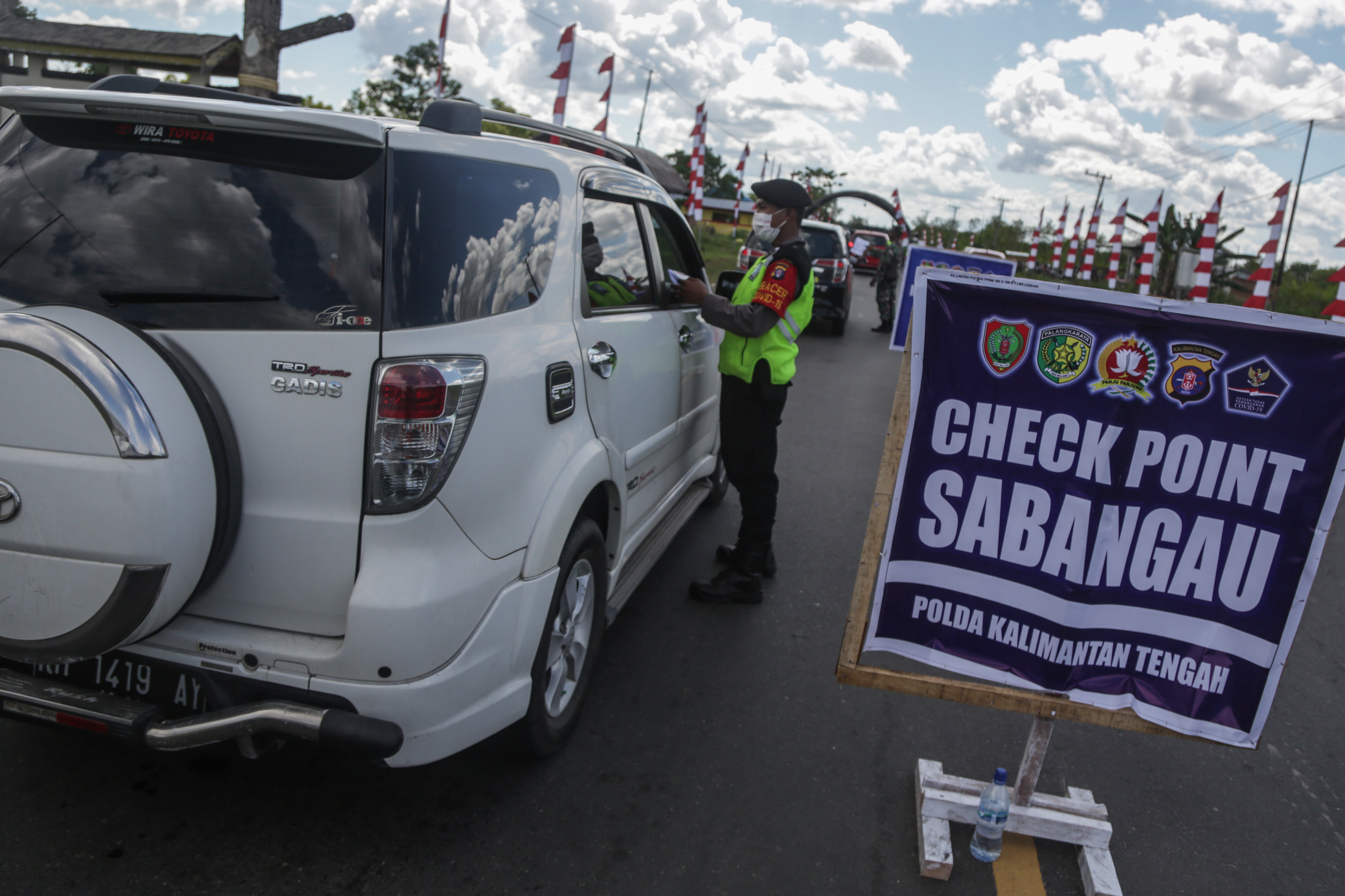 Petugas keamanan memeriksa dokumen perjalanan di masa PPKM