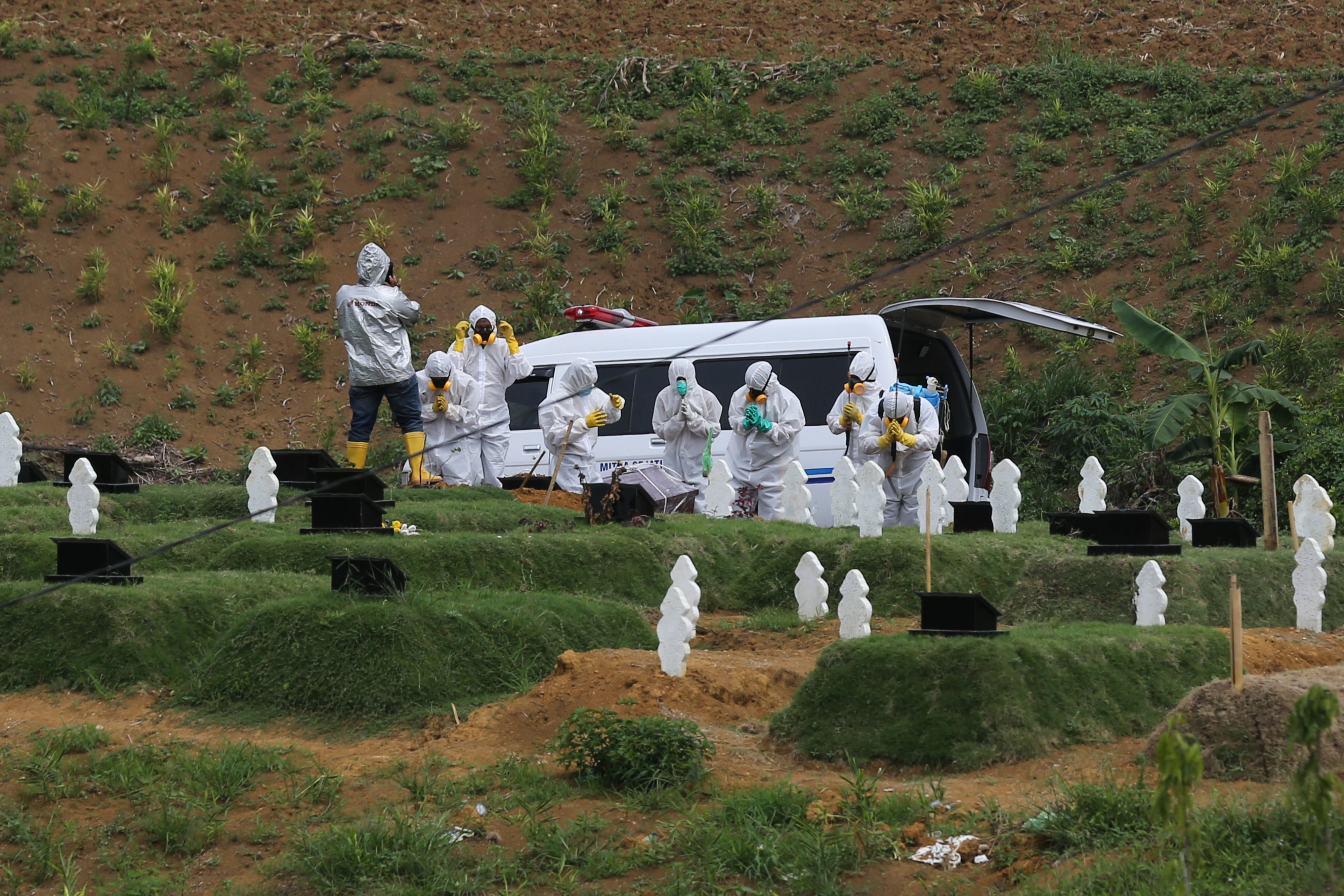 Petugas memakamkan jenazah korban COVID-19 dengan protokol kesehatan di TPU khusus COVID-19 Simalingkar B, Medan Tuntungan, Sumatera Utara.