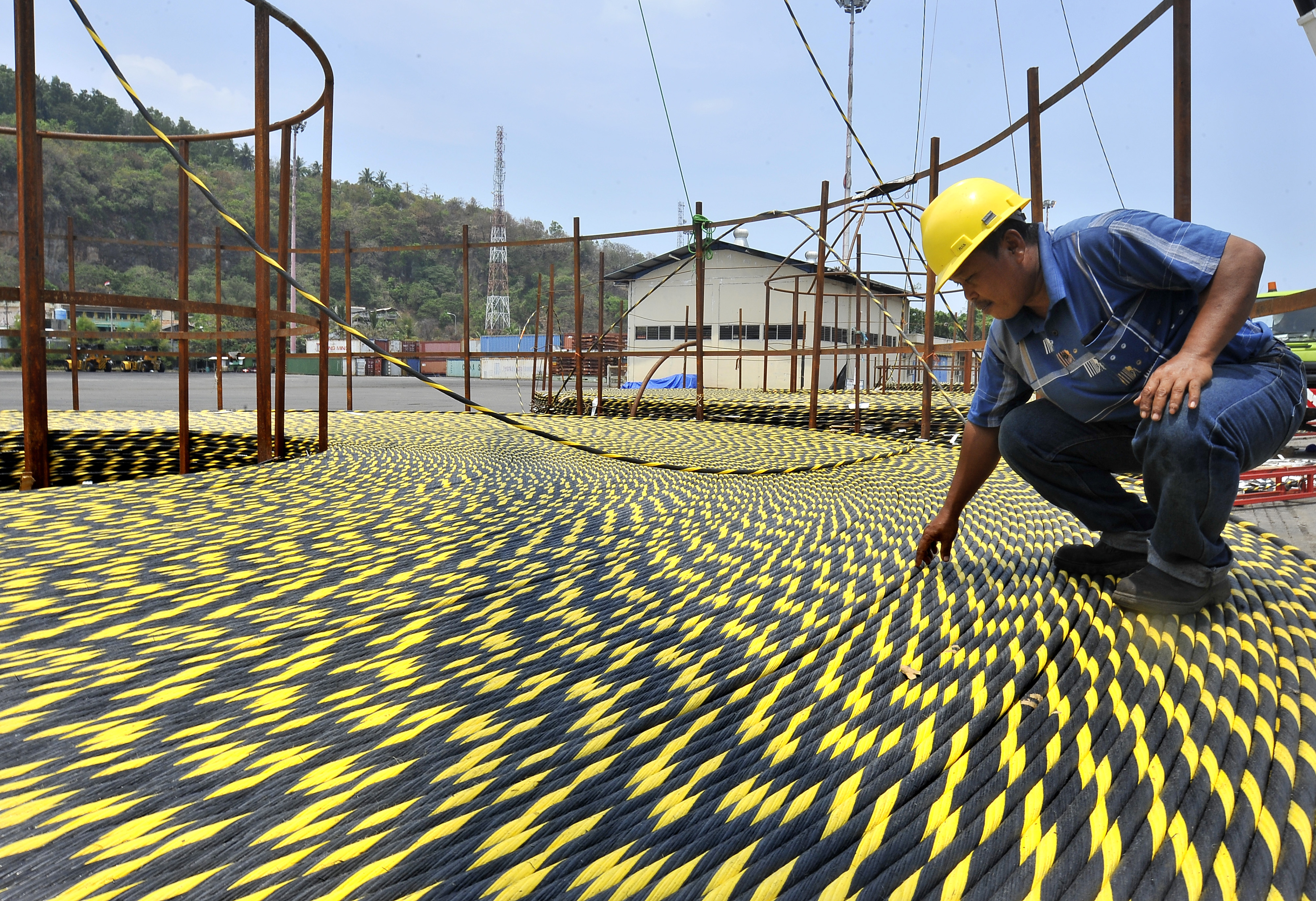  Pekerja memeriksa gulungan kabel optik sebelum ditanam di bawah laut Jakarta Surabaya