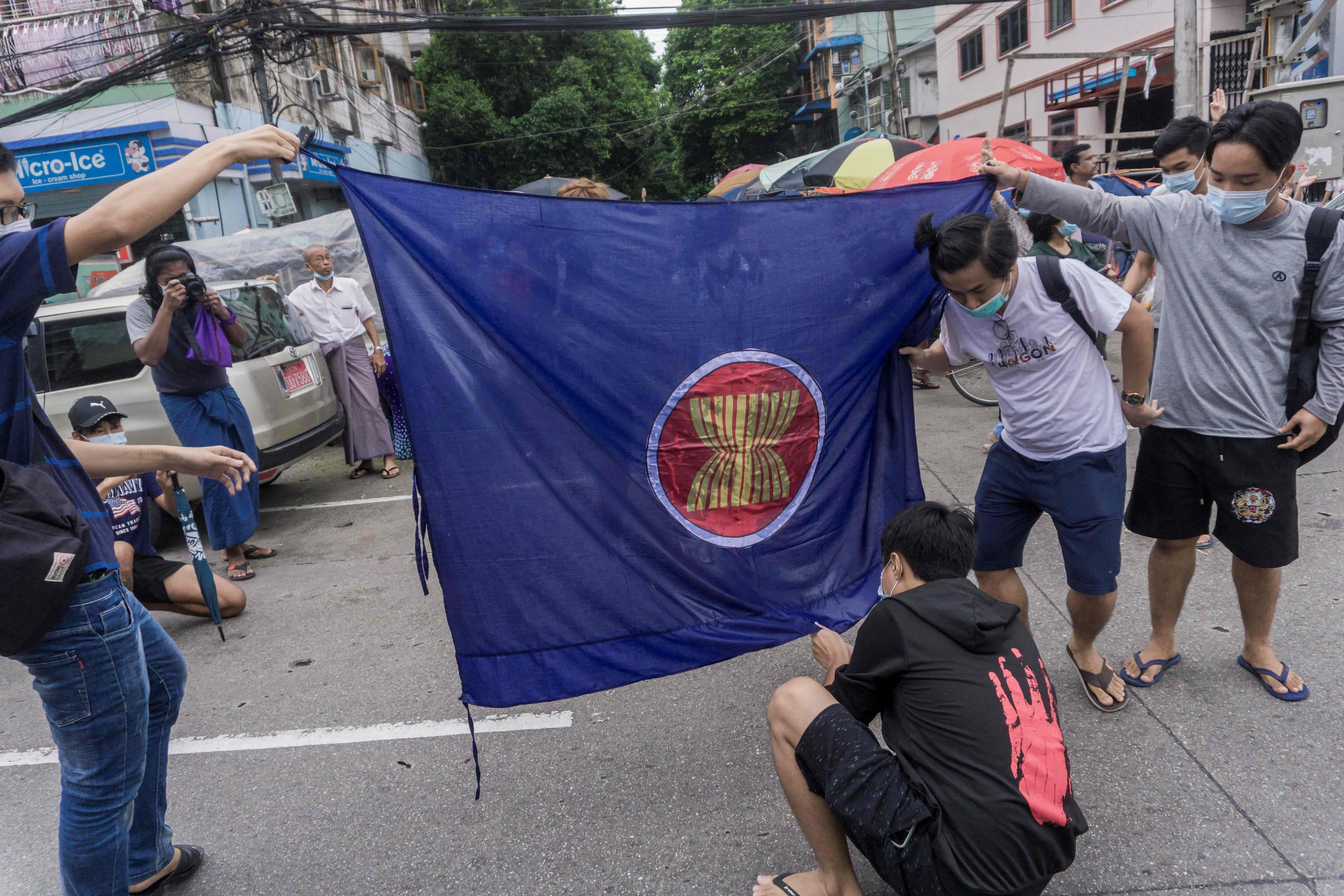 Demonstran membakar bendera ASEAn dalam aksi demonstrasi di Yangon, Myanmar.