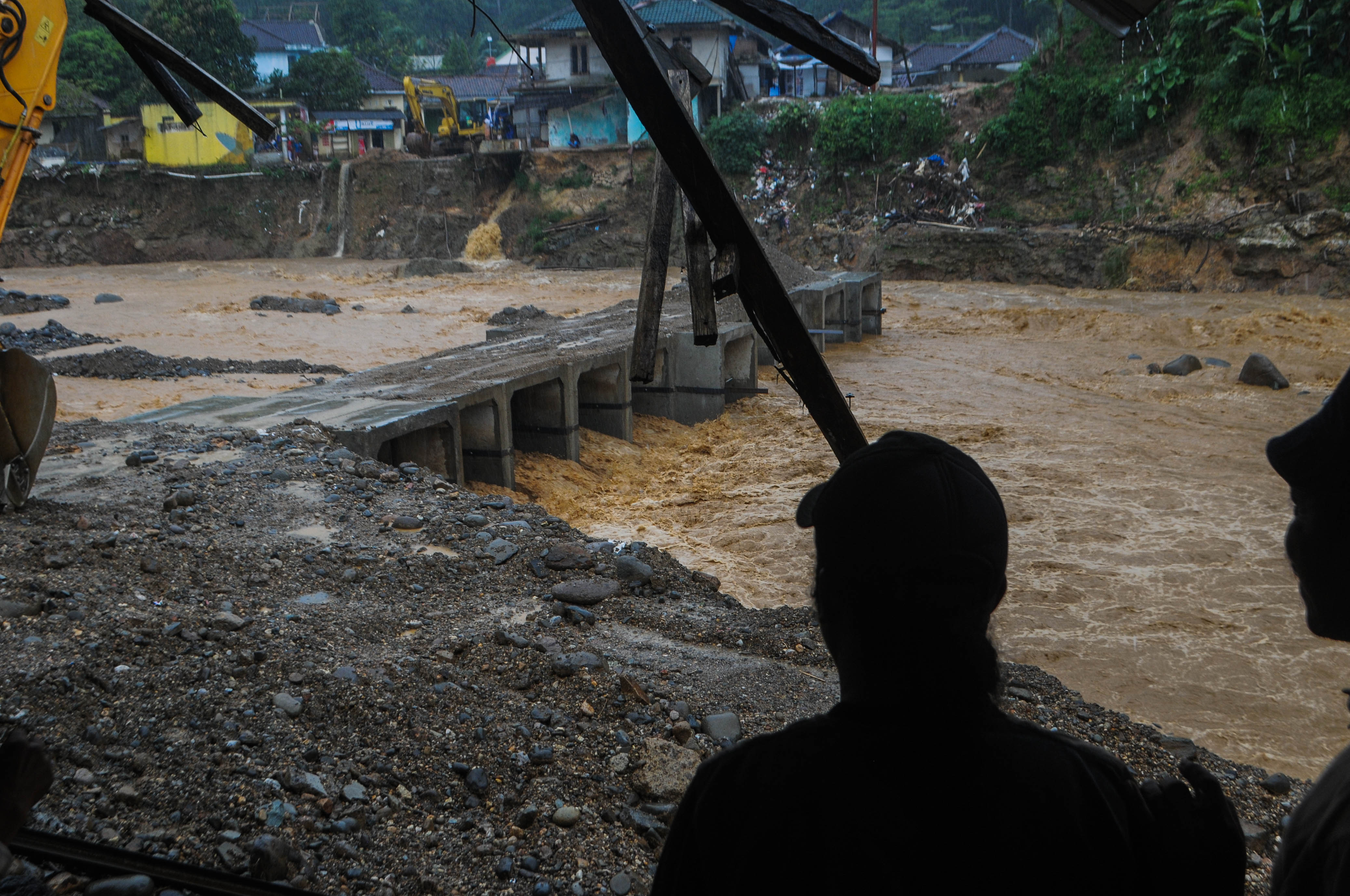 Warga melihat kondisi jembatan limpas diterjang luapan sungai di Kampung Muhara, Lebak, Banten, Senin (23/3/2020)
