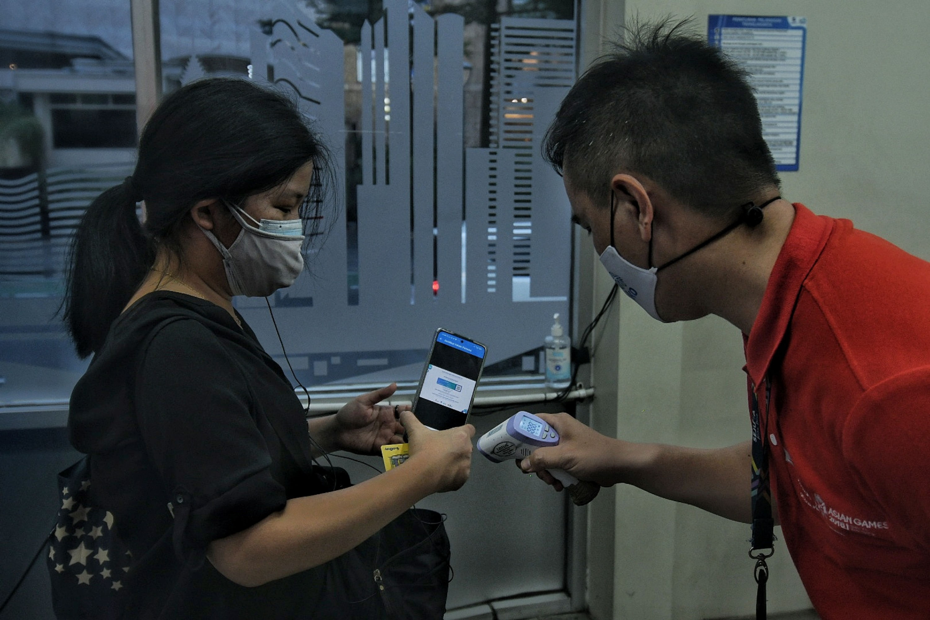 Petugas memeriksa kartu vaksin calon penumpang bus Transjakarta di Halte Bus Transjakarta Bundaran HI, Jakarta