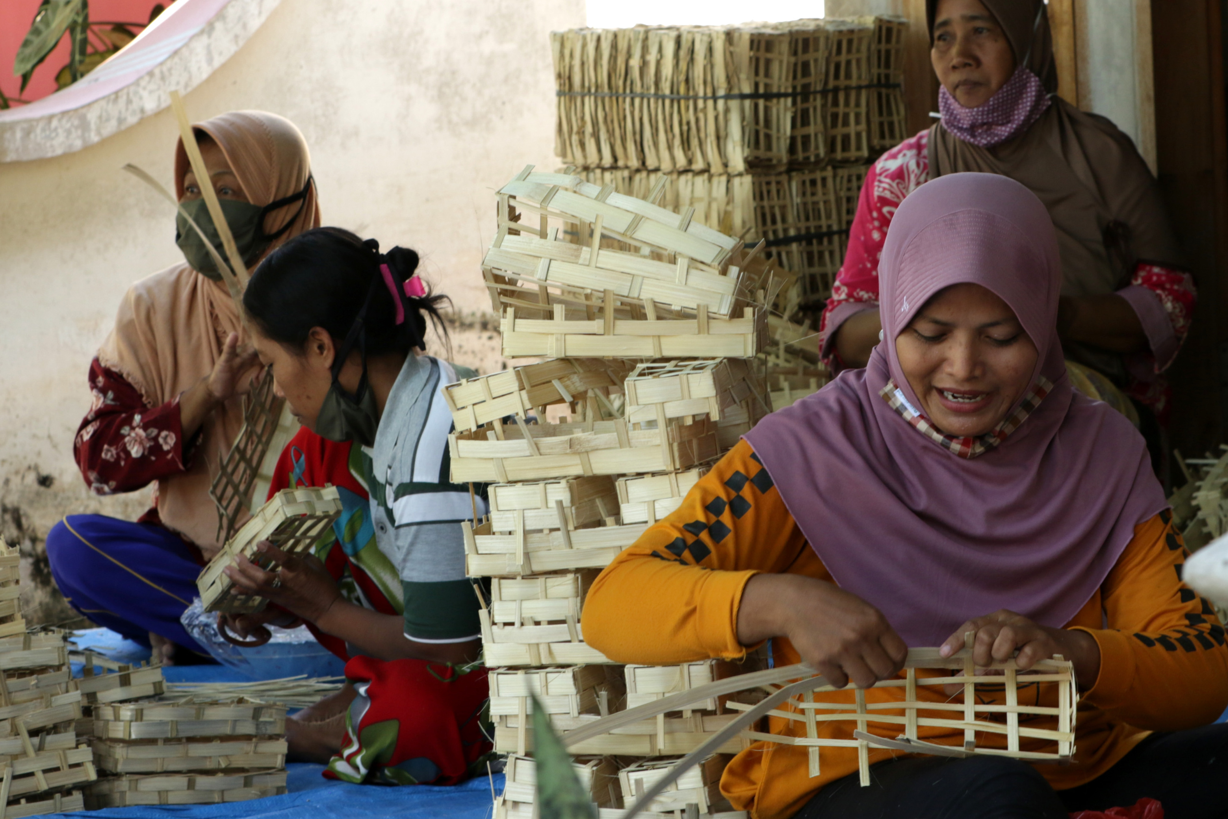 Perajin membuat godhong atau tempat ikan di industri rumahan Desa Kemendung, Muncar, Banyuwangi, Jawa Timur, Jumat (28/5).