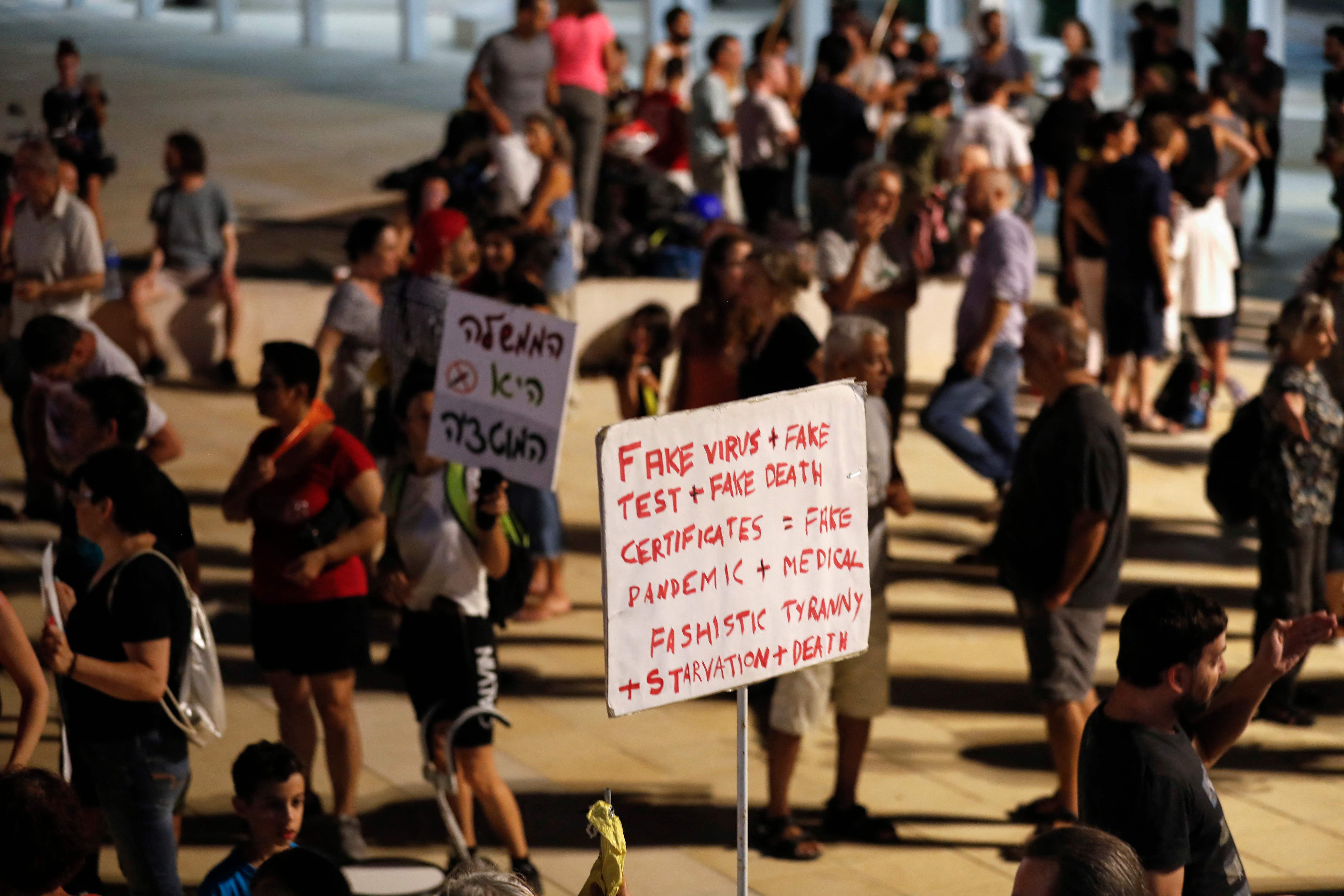 Ratusan orang Israel membawa poster menolak pembatasan sosial terkait Covid-19 di Tel Aviv, Israel, pada Sabtu (31/7).